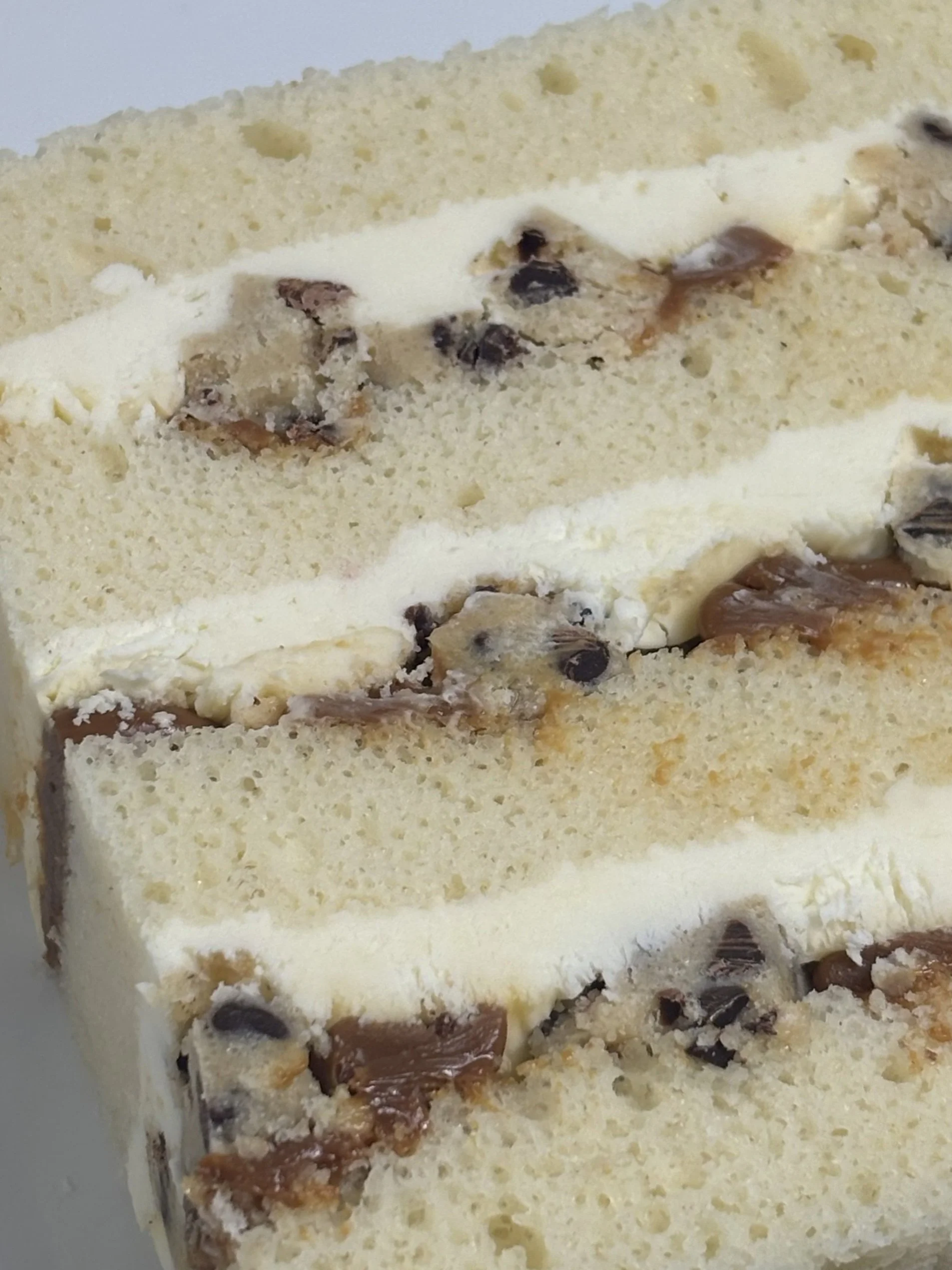 Cookie Dough: A vanilla cake filled with a white chocolate mousse, chocolate chip cookie dough pieces, and caramel.
