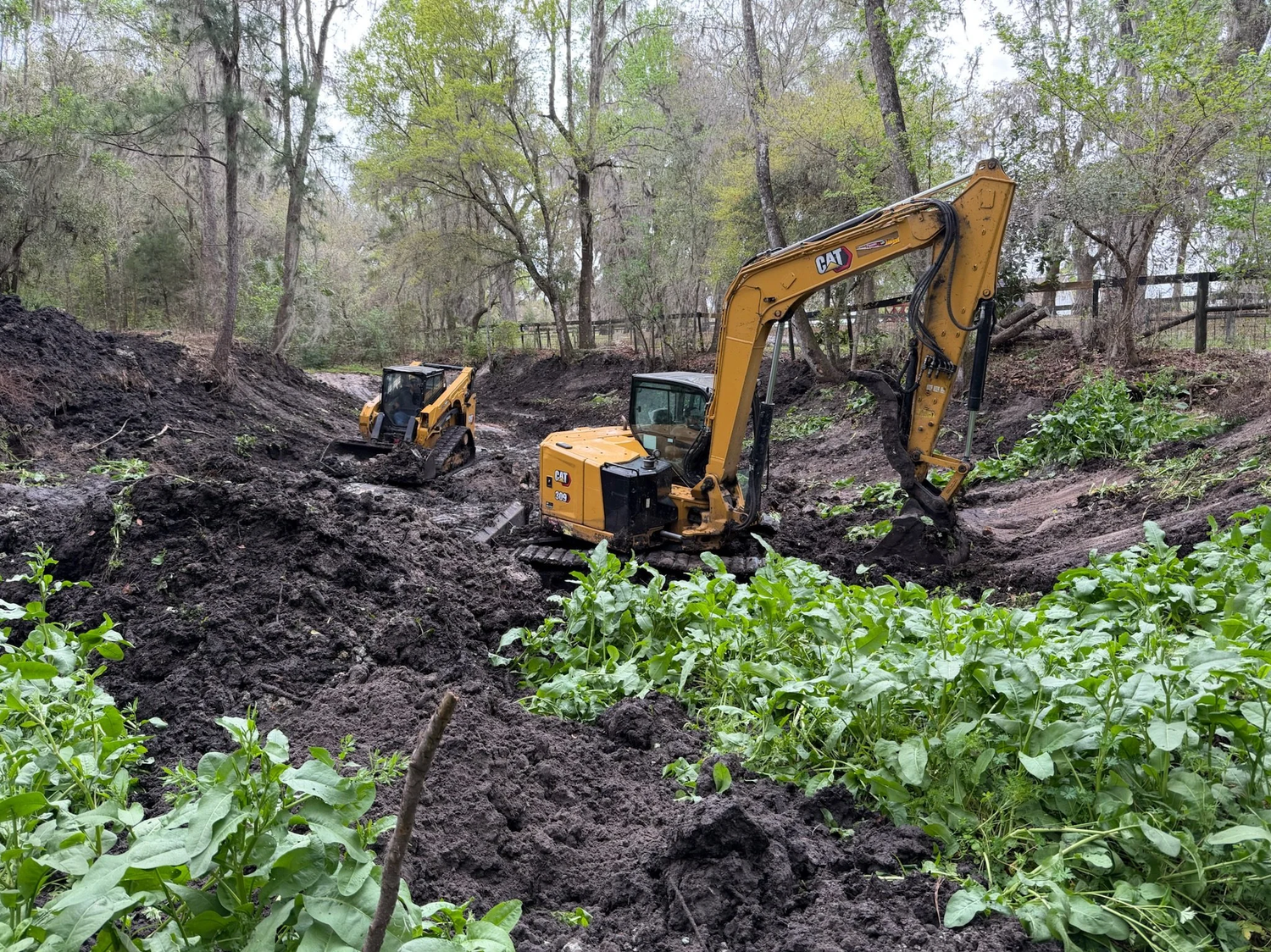Excavators clearing a pond, ditch and drainage area