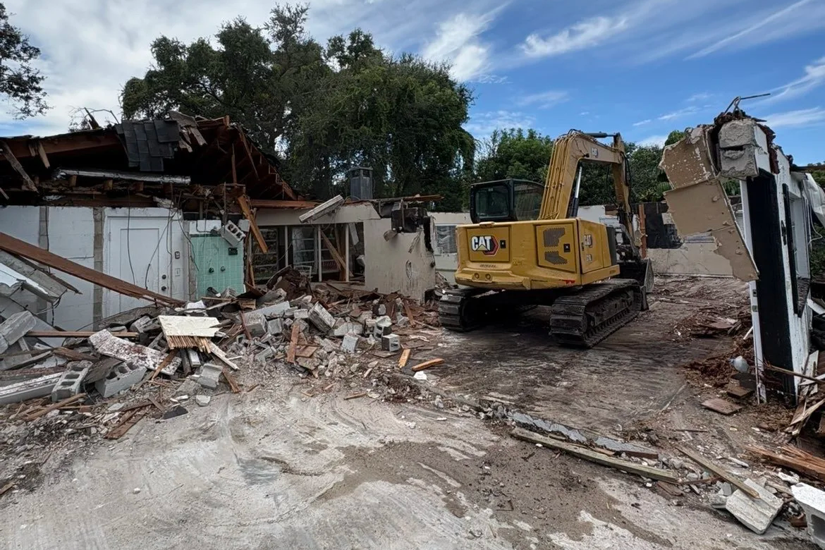 Excavator demolishing a building and removing debris