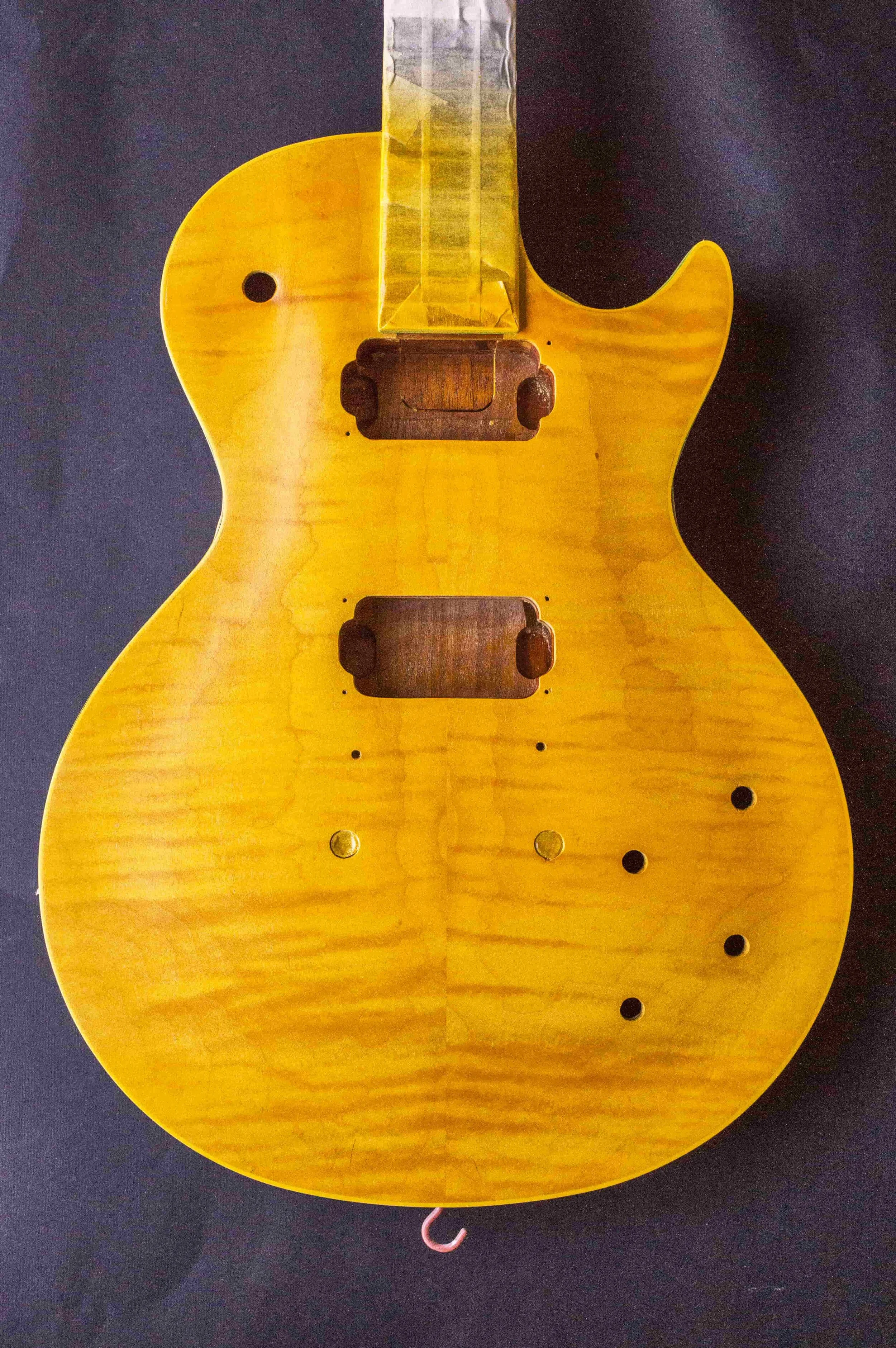 After achieving a level surface with cellulose sanding sealer, the bursting process begins with two coats of aniline yellow.