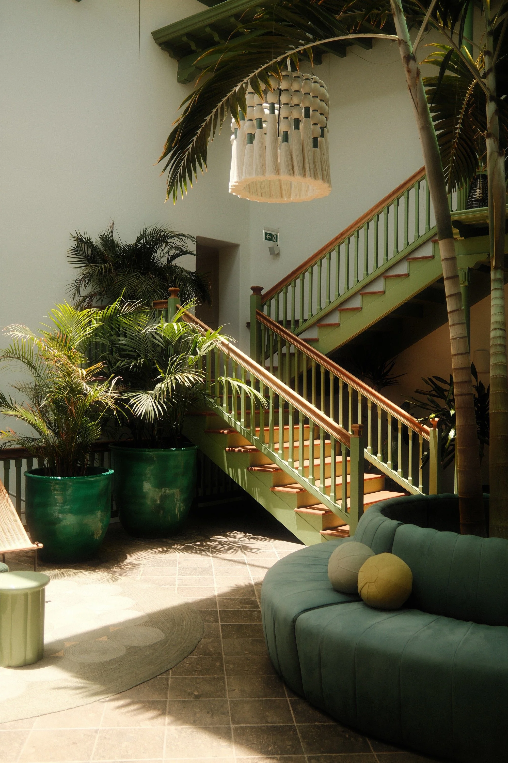 Green stairway and light-filled hotel interior