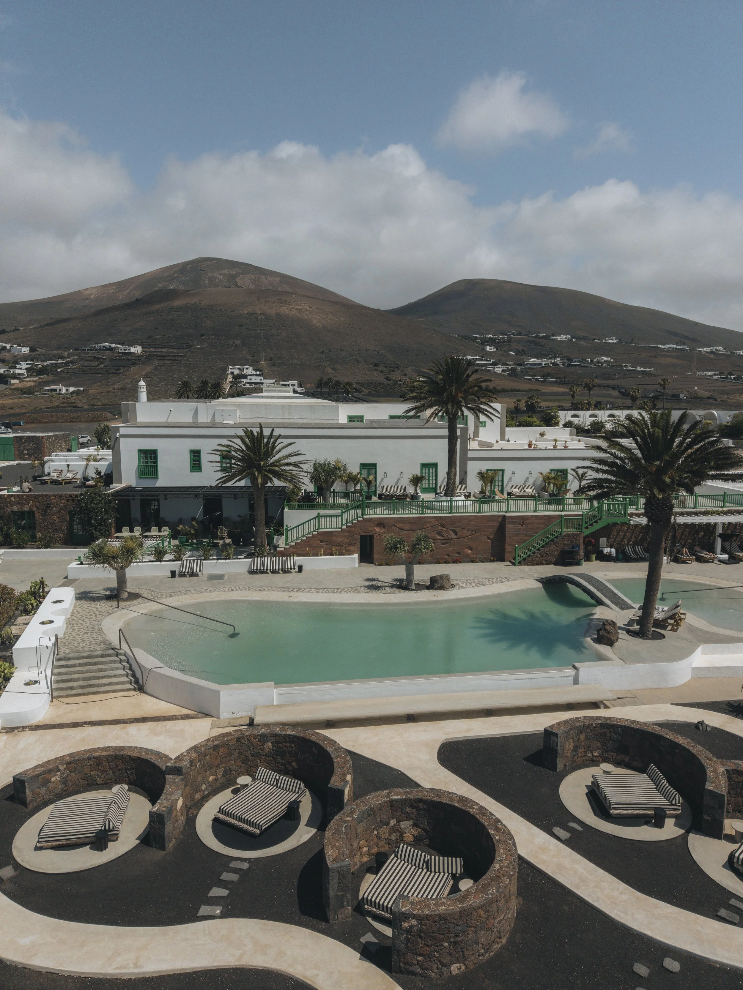 Drone view of César Lanzarote, its pool and volcanic surroundings.
