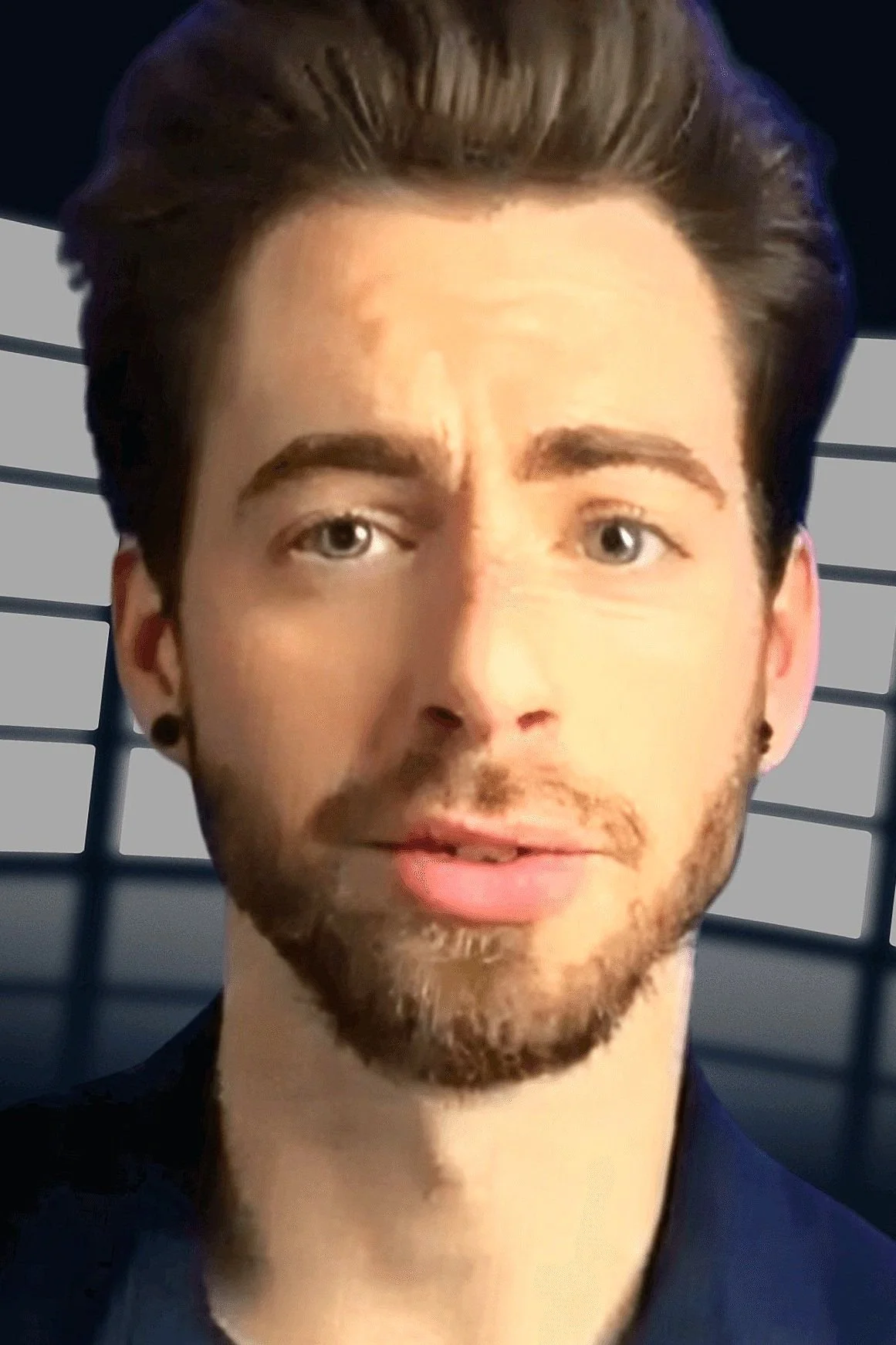 Close-up of a young man with dark brown hair, styled back, with light eyes, a light beard, and wearing a dark shirt, standing in front of a background with horizontal lines.