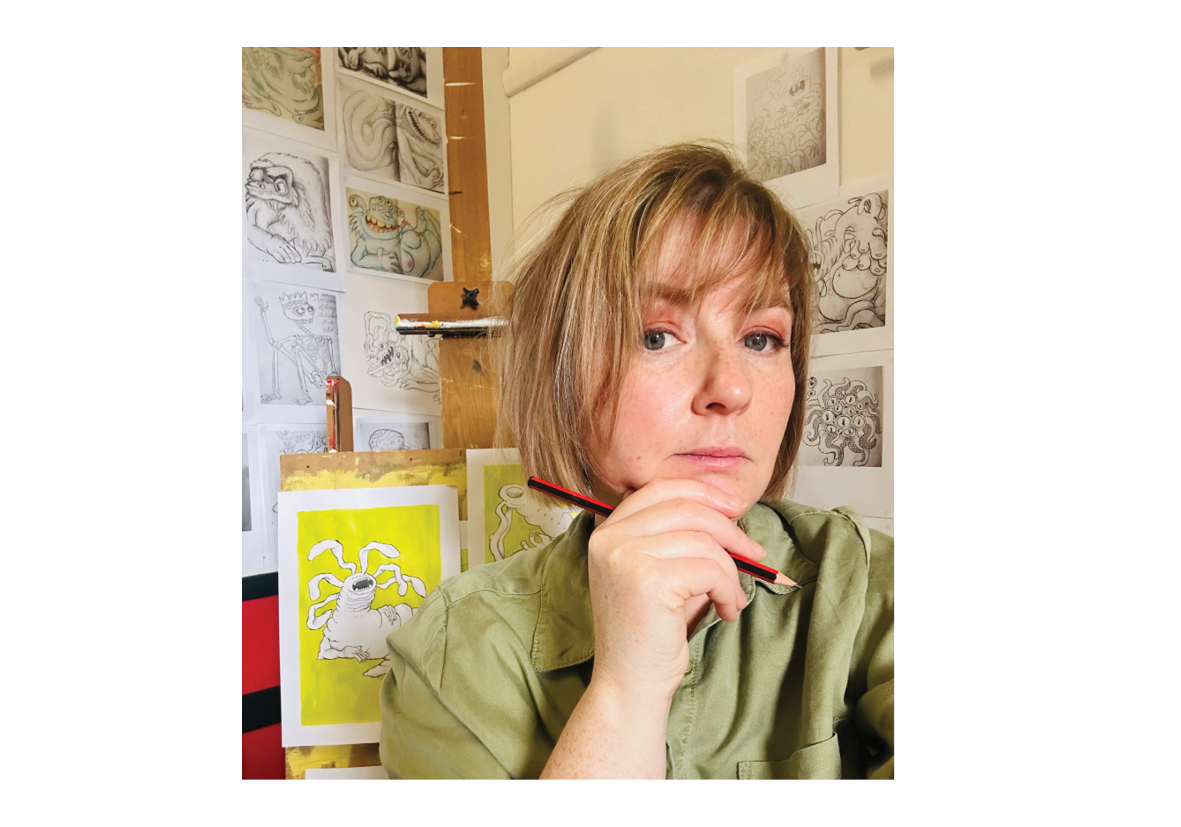 Wen Dixon-Whiley close up image sitting with a pencil in her studio with an easel and drawings in the background