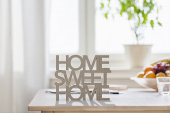 Decorative wooden sign reading 'Home Sweet Home' on a kitchen table