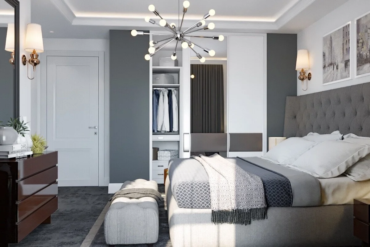 Modern bedroom with gray and white decor, a large upholstered bed with white pillows, a gray blanket, and artwork above the bed. There are wall-mounted lamps, a wooden dresser, an open closet with hanging clothes, and a stylish chandelier.
