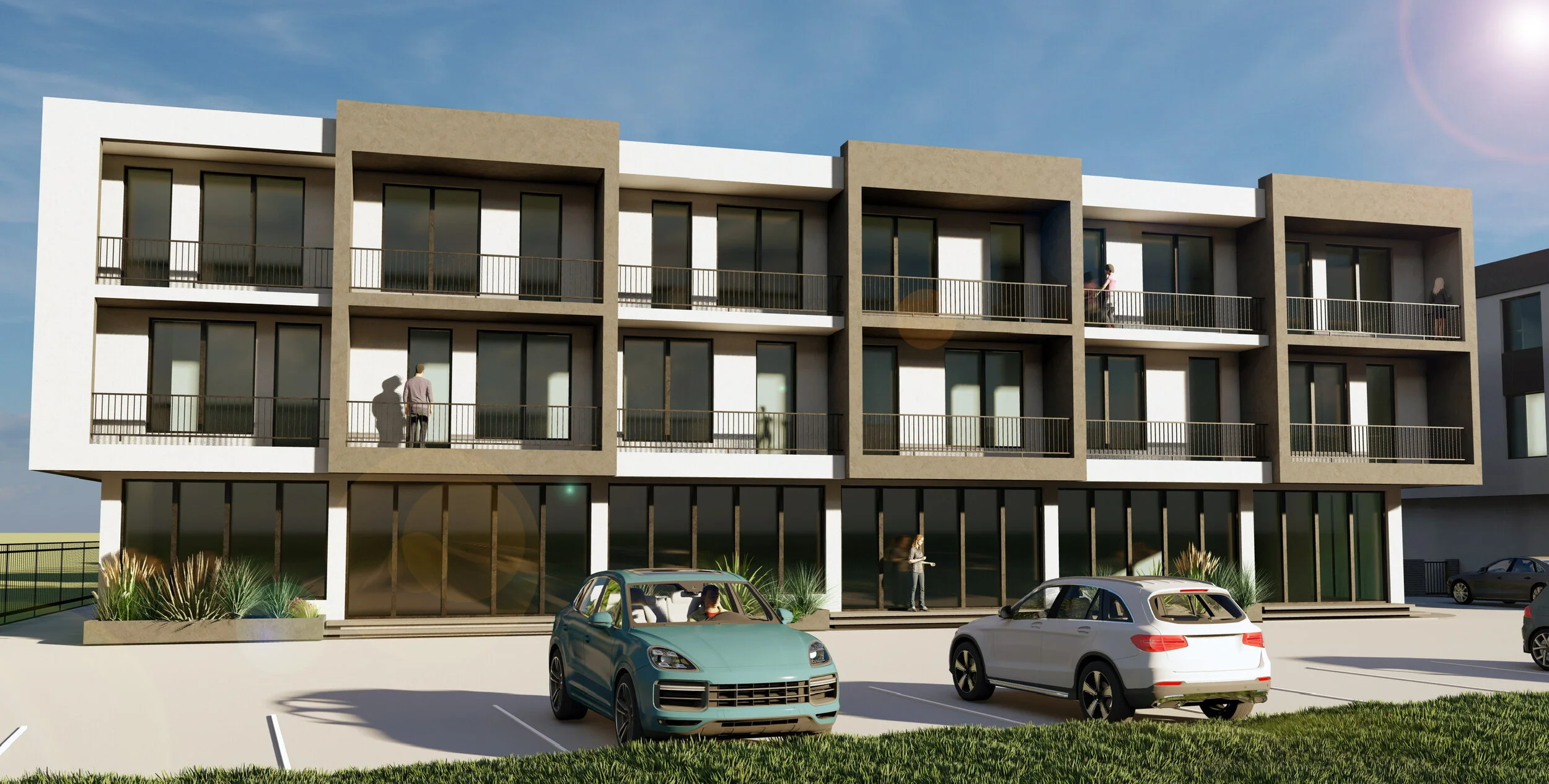 A modern four-story apartment building with large glass windows and balconies, a parking lot with several cars, and people standing and walking outside on a sunny day.