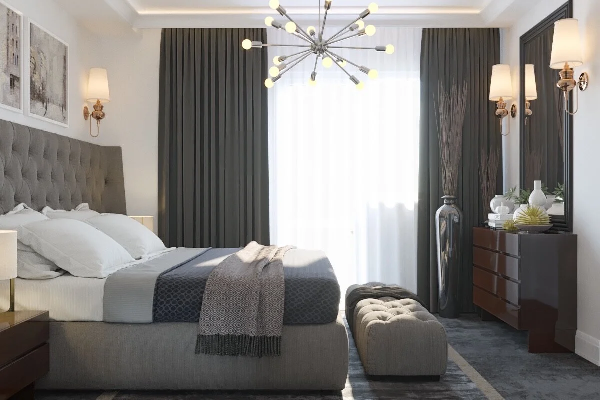 Modern bedroom with a tufted bed, white bedding, dark curtains, a unique chandelier, a wooden dresser with decorative vases, and a large mirror.