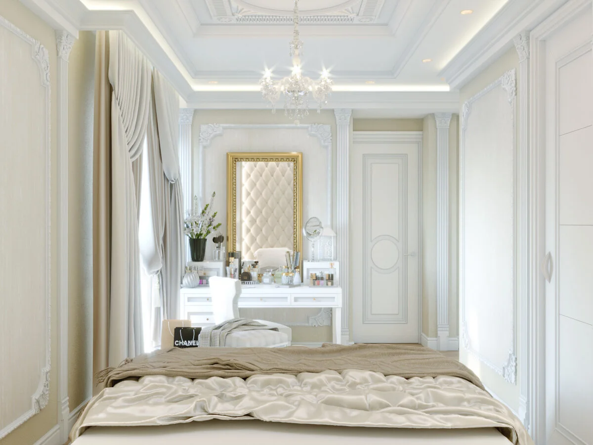 A luxurious, elegant bedroom with white ornate walls, a large bed with satin bedding, a vanity with makeup products and a mirror, and a chandelier hanging from a decorated ceiling.