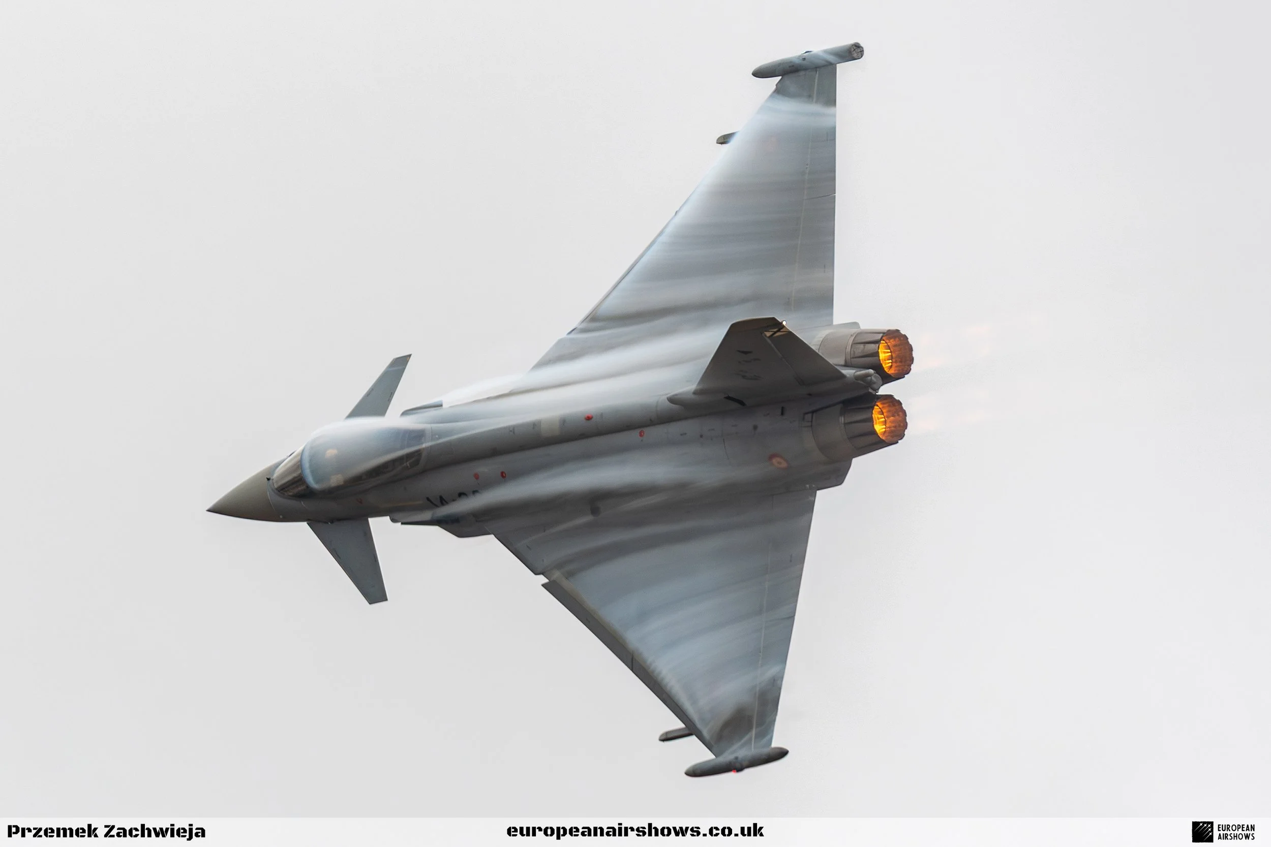 A fighter jet plane flying in the sky with afterburners on.