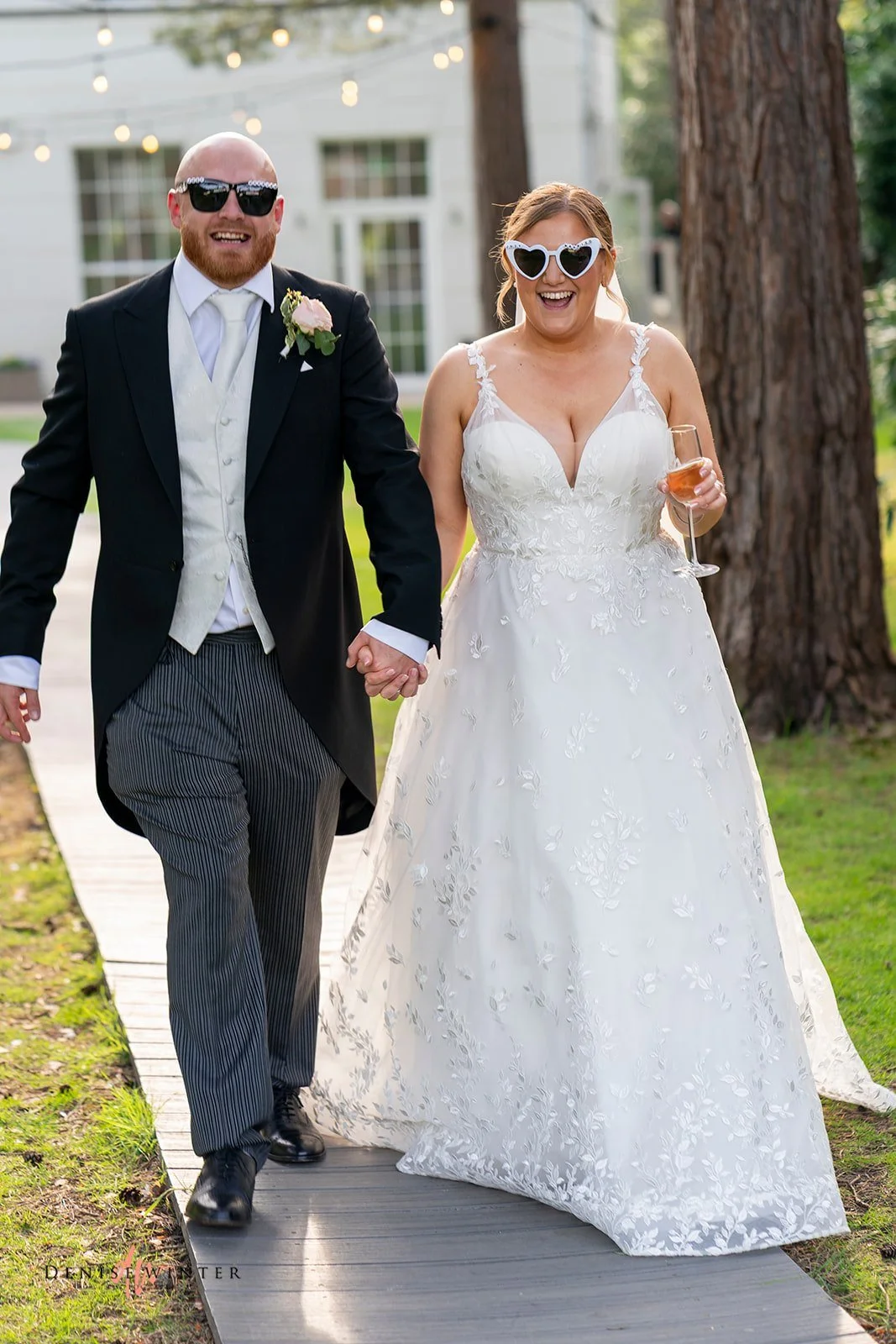 Real Boo Bride Ashley wearing her lace dress from Boo Bridal and her new husband wearing sunglasses, drink in hand, ready to celebrate their marriage with family and friends after their wedding ceremony
