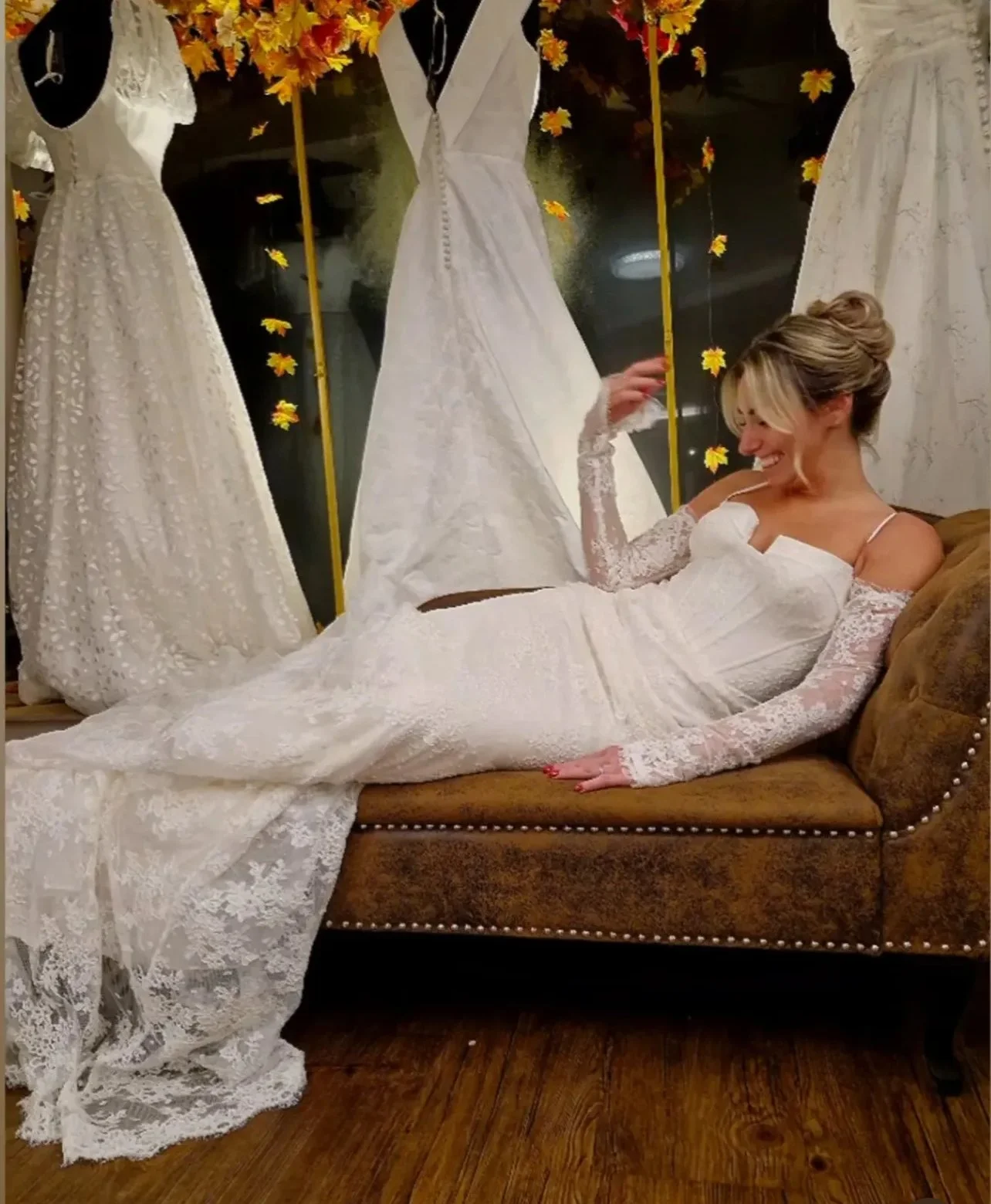 Beautiful bride reclining on a chaise wearing a tight lace wedding dress