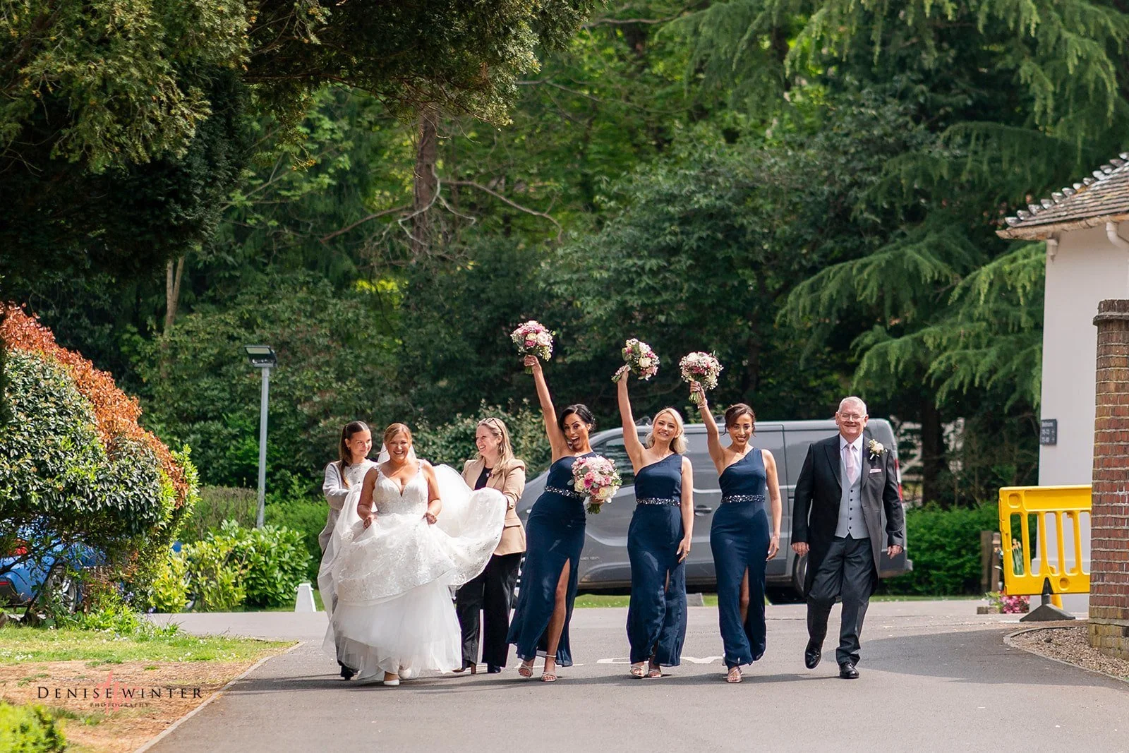 Real Boo Bride Ashley and her bridesmaids walking towards the ceremony with her dad, and Emma & Poppy, her seamstress and stylist, who came to dress her on the morning of the wedding, in the grounds of Gorse Hill hotel.