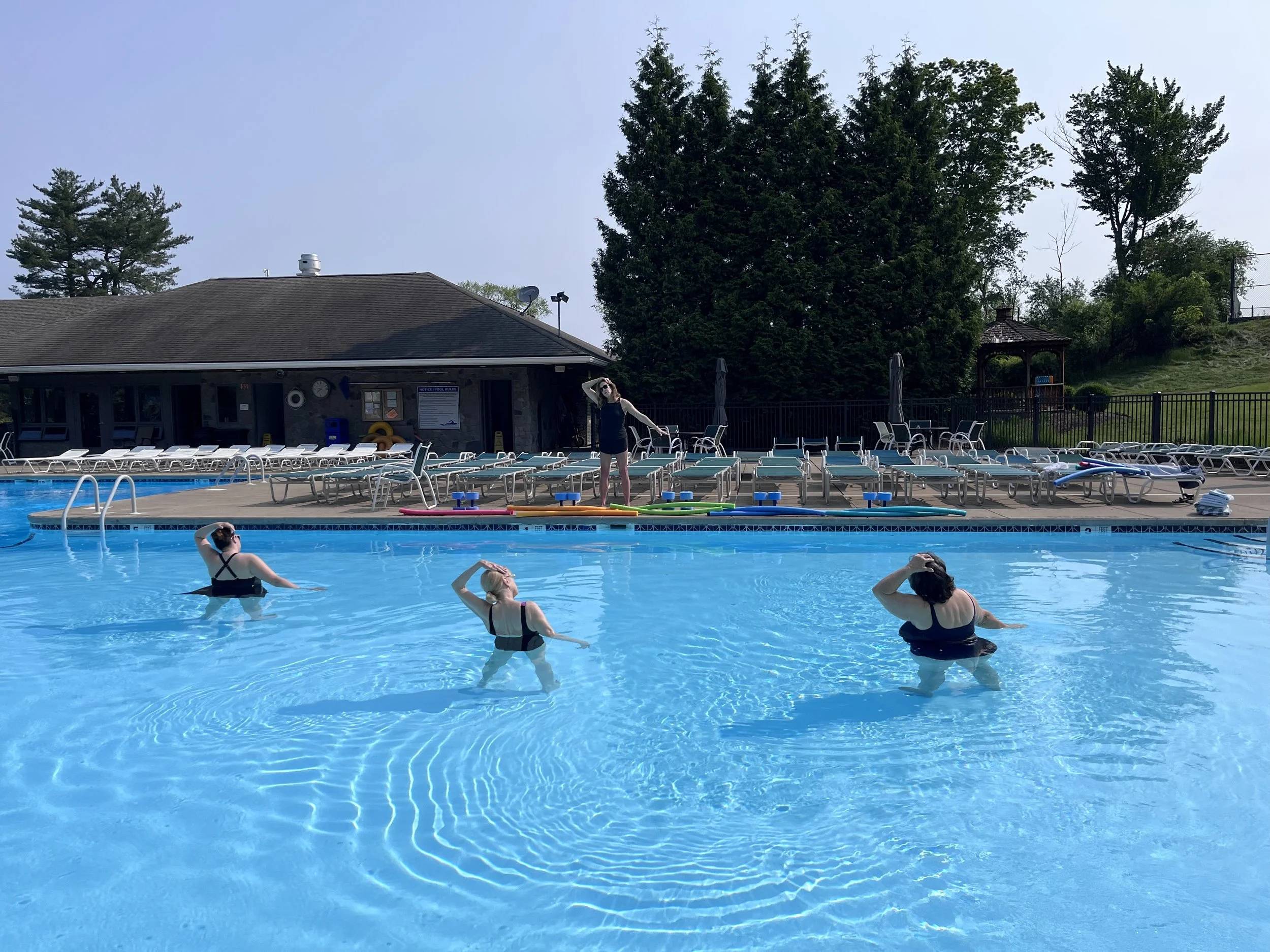 Group stretch during Aqua Yoga class in the pool at Glen Oak Country Club in Clarks Summit, Pennsylvania.
