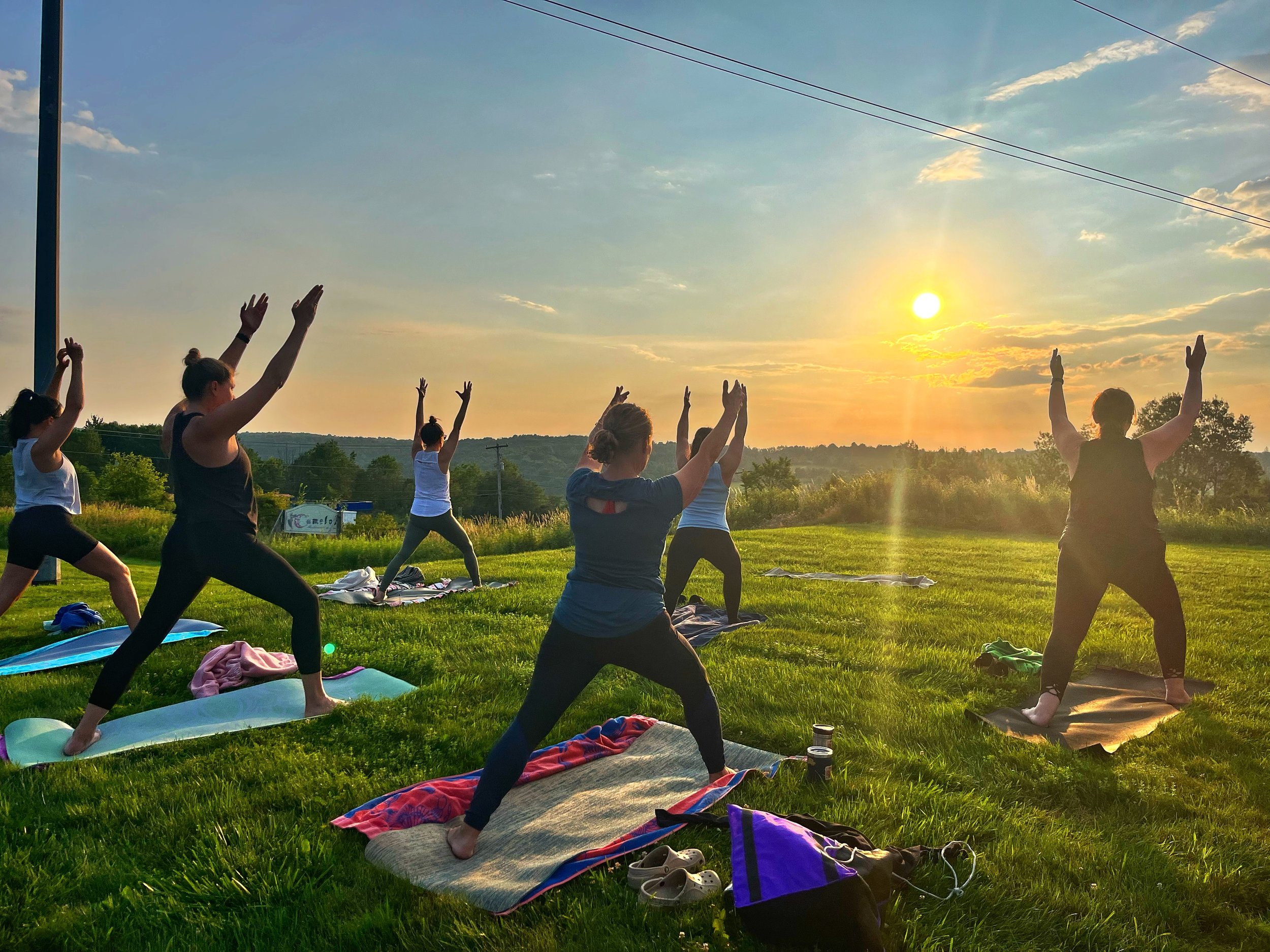 People practicing Warrior I at Camelot Restaurant & Inn during a yoga class led by Jaya Yoga Studio in Clarks Summit, Pennsylvania.