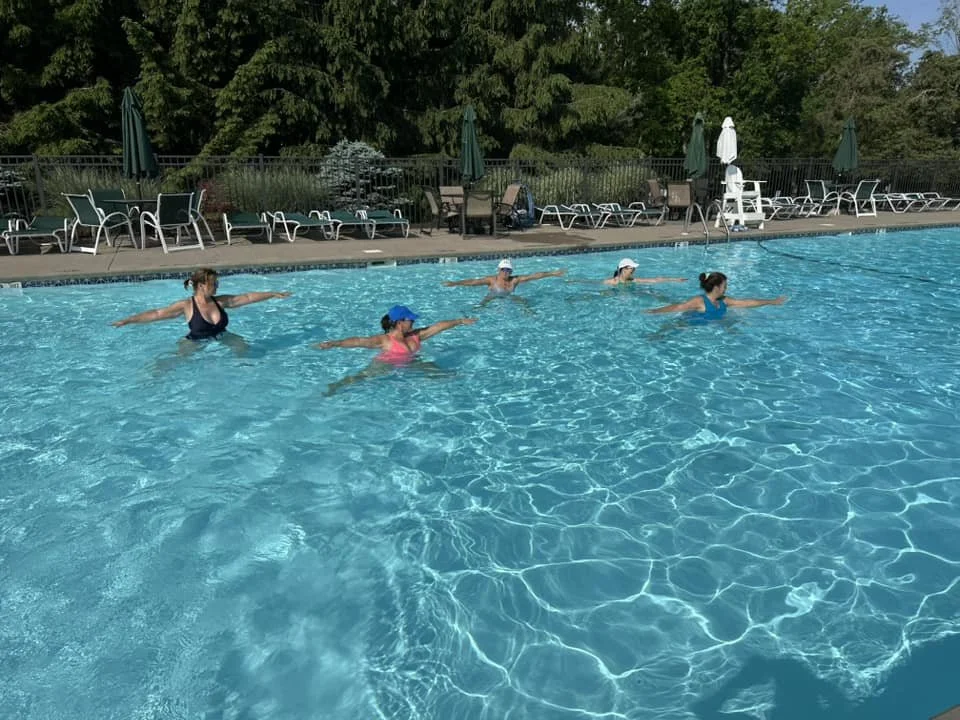 Group Aqua Yoga class doing Warrior 2 in the pool at Glen Oak Country Club in Clarks Summit, Pennsylvania.