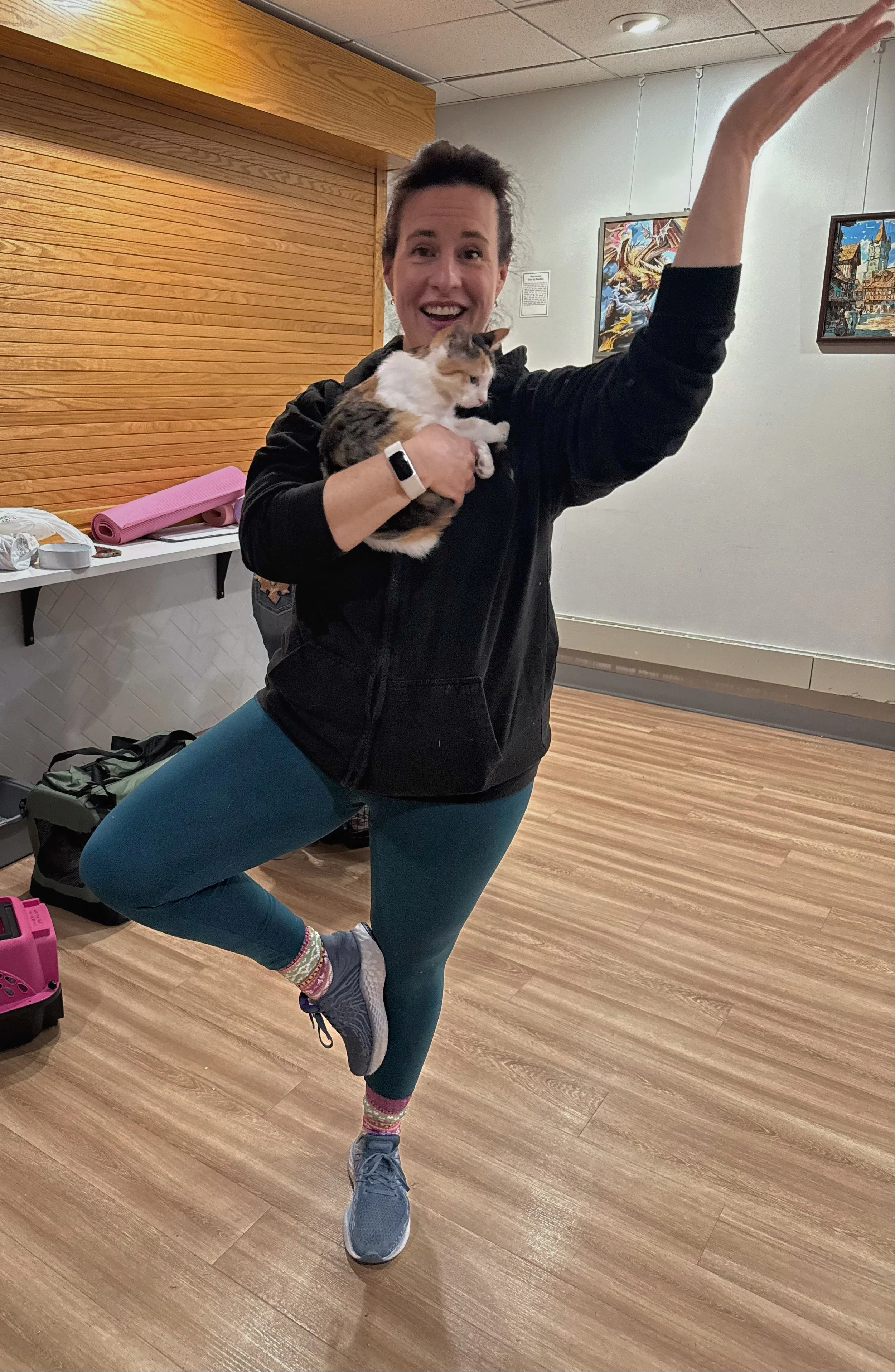 During Cat Yoga at the Abington Community Library in Clarks Summit, PA, a participant holds a playful kitten from KitKat Mission while balancing in “Cat in the Tree Pose.”