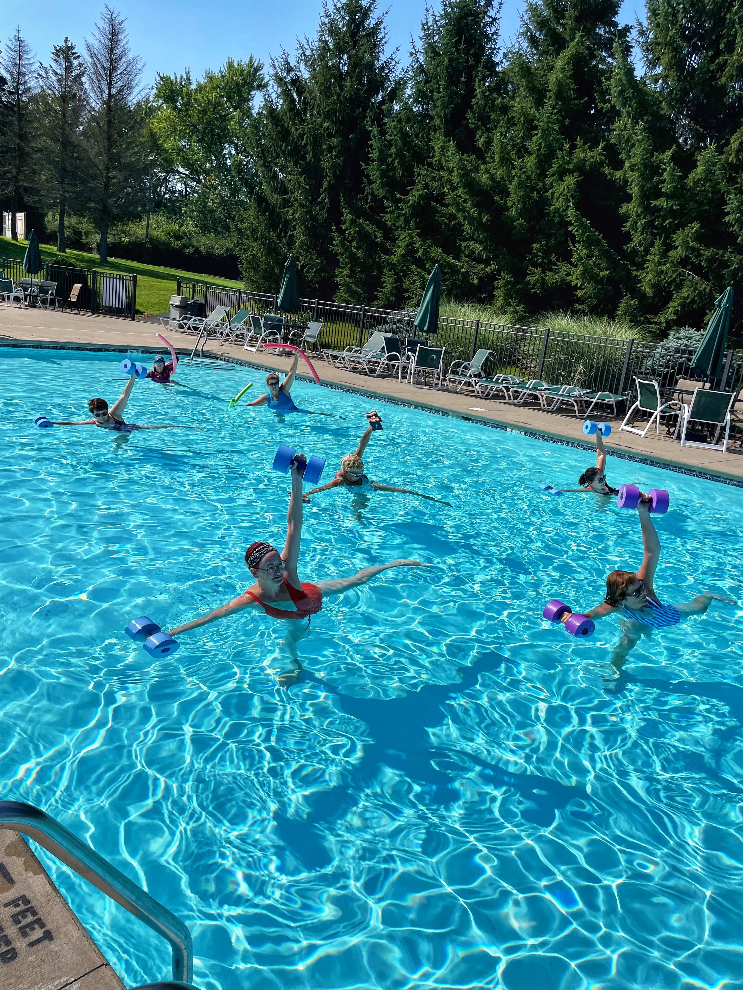 Participants practicing half moon in the pool with weights during Aqua Yoga with Jaya Yoga at Glen Oak Country Club in Clarks Summit, Pennsylvania.