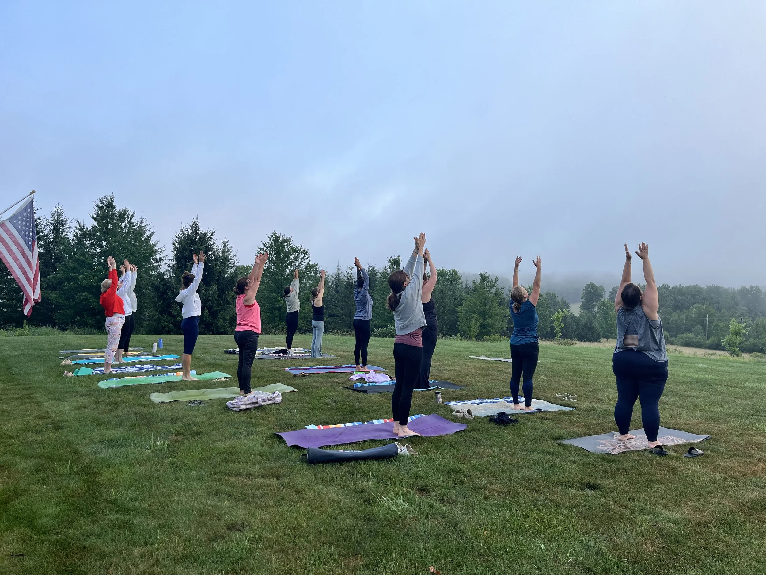 Members of the Jaya Yoga Studio Sunrise Crew practice outdoor yoga together on a misty summer morning in Northeastern Pennsylvania.