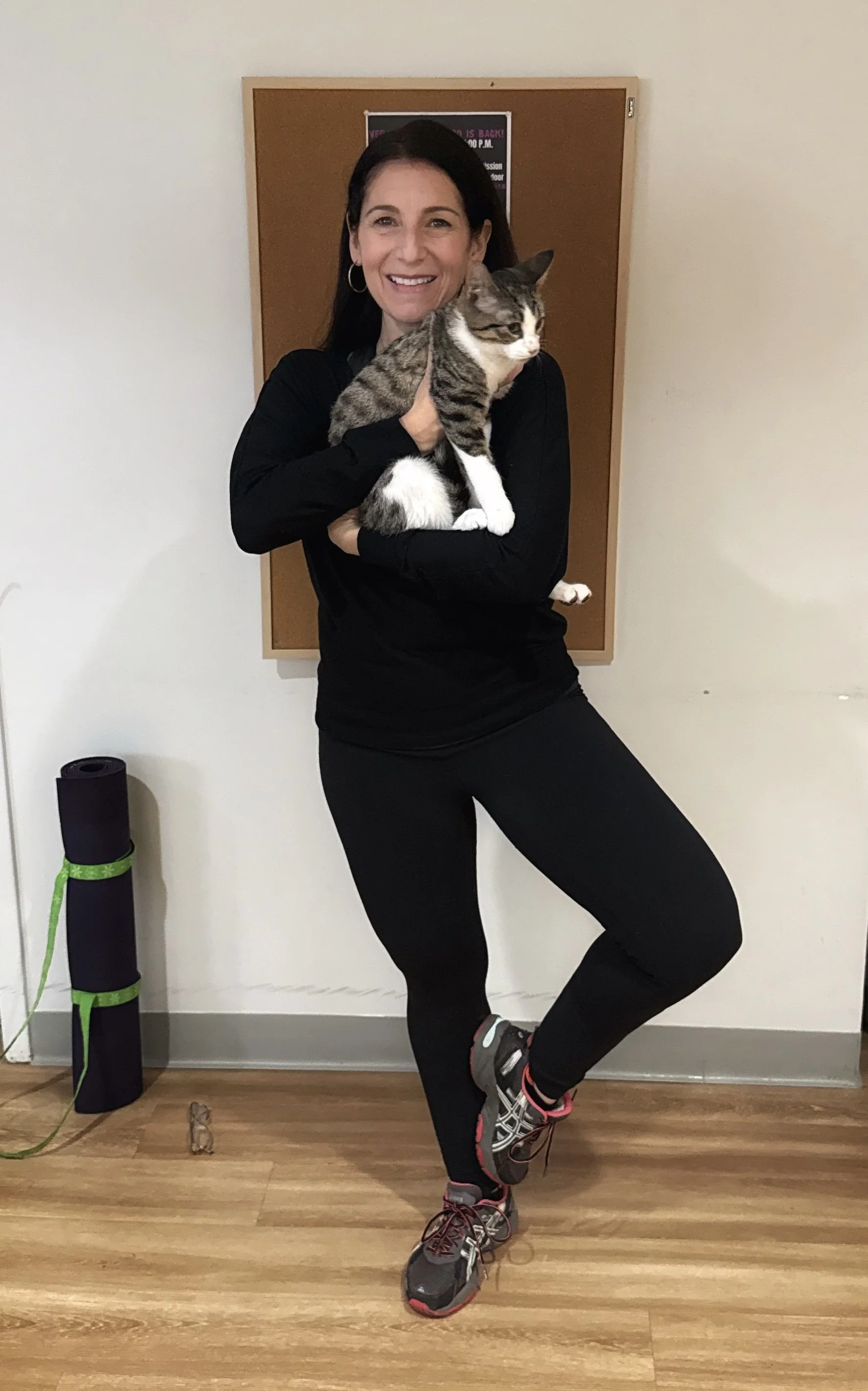 Tree pose gets a feline twist! Yoga instructor, Hilary Steinberg, from Jaya Yoga demonstrates  “Cat in a Tree Pose” during Cat Yoga with rescue cats from KitKat Mission at the Abington Community Library in Clarks Summit, Pennsylvania.