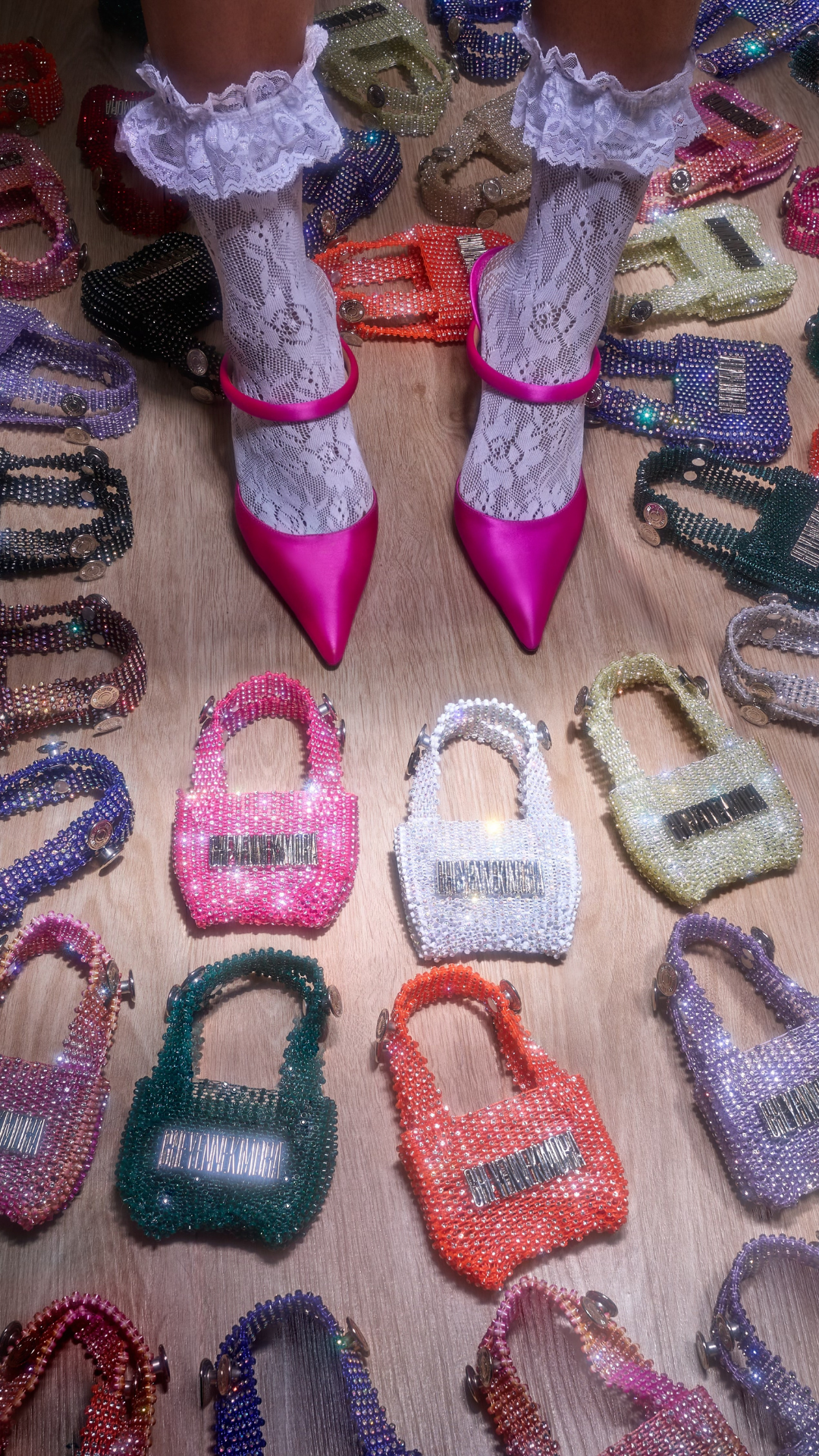 model's feet surrounded by mini bags in every color.