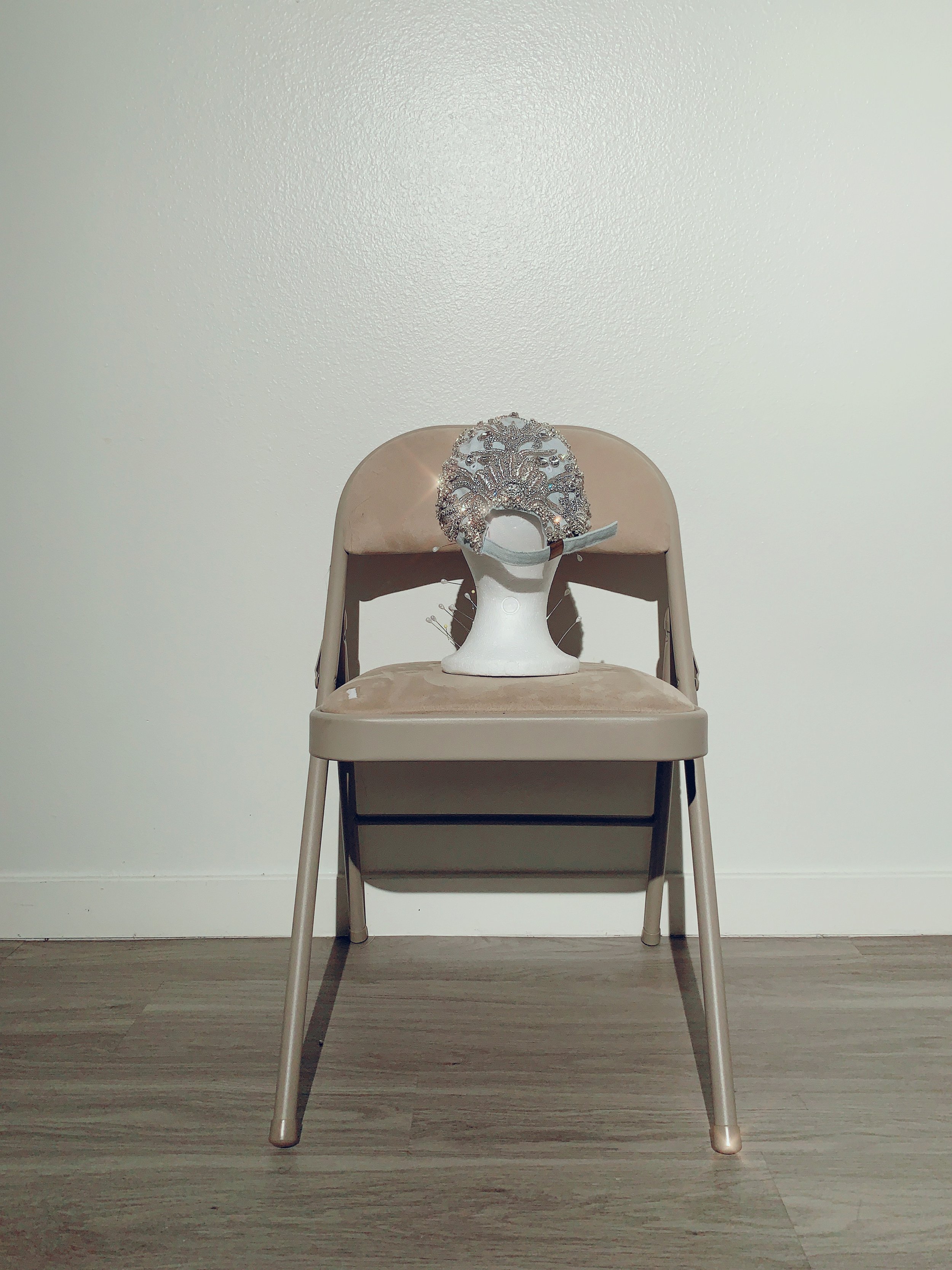 Sculptural couture headpiece by Cheyenne Kimora displayed on a chair.