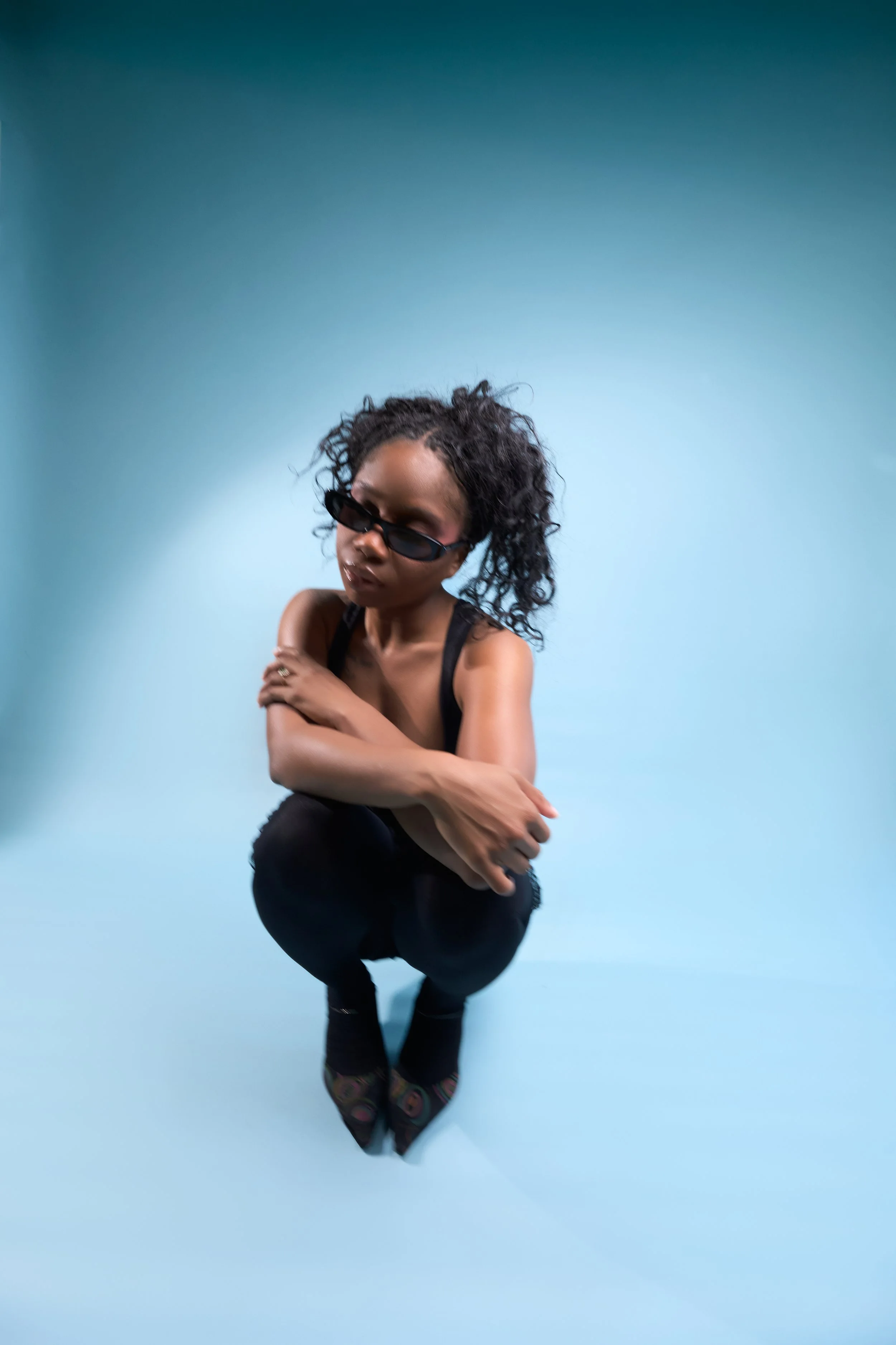 squatting portrait with head gently tilted and arms crossed