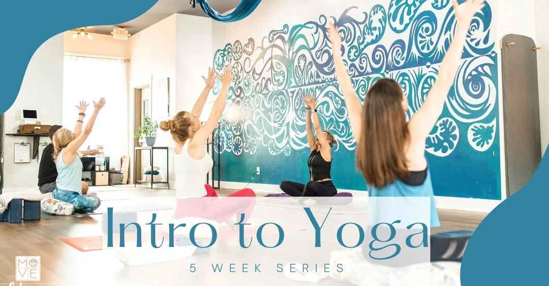 Group of four women participating in a yoga class at Move Fitness and Yoga in Bluffton, SC with a blue and white painted wall, practicing seated yoga with their arms raised.