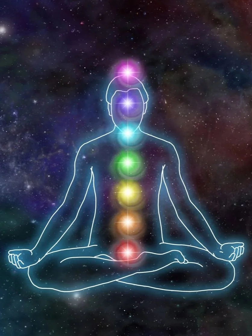 Outline of a person sitting in a meditative pose with seven colored chakras aligned along the body, set against a starry galaxy background.