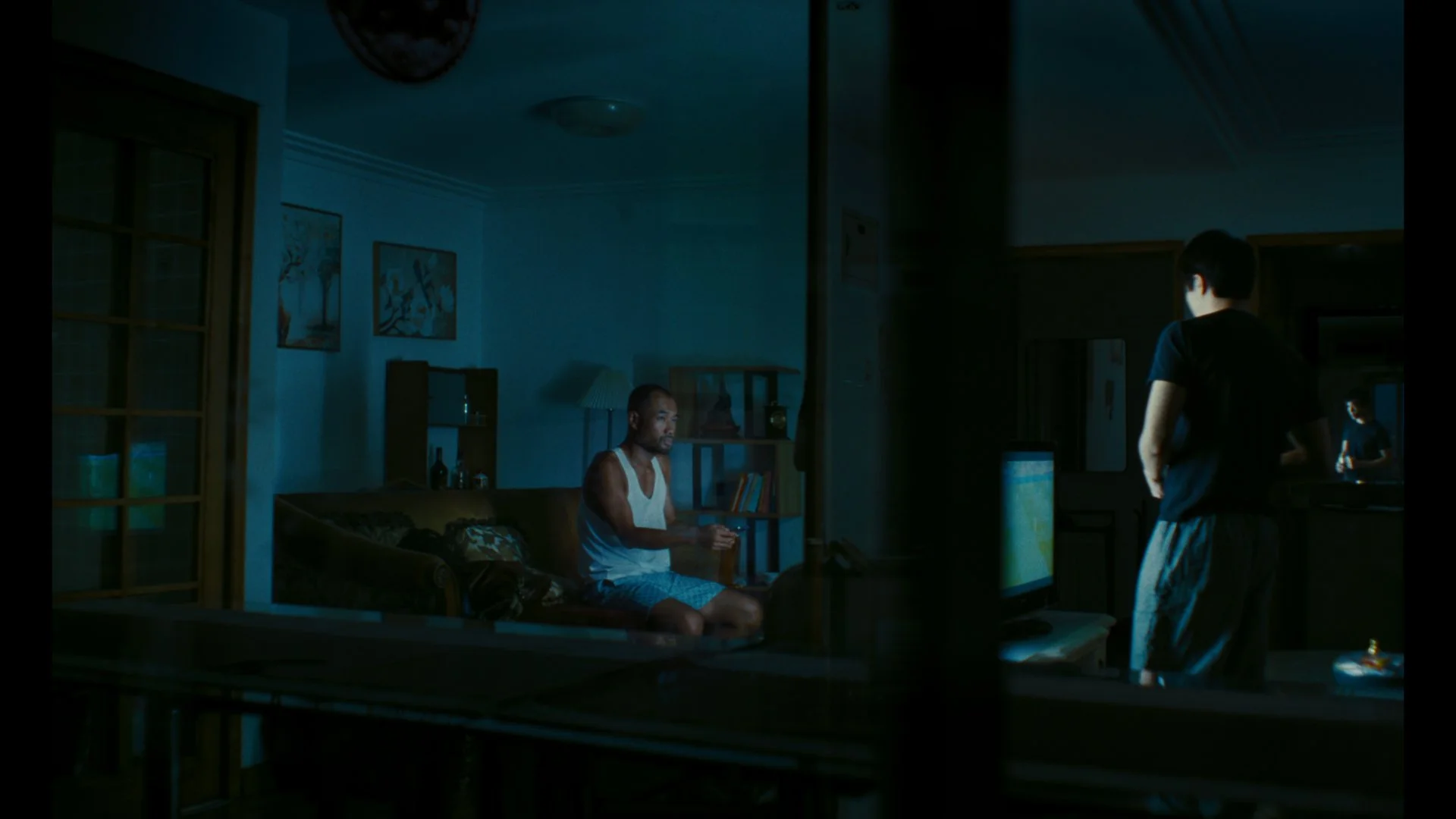 two people speak inside a house at night