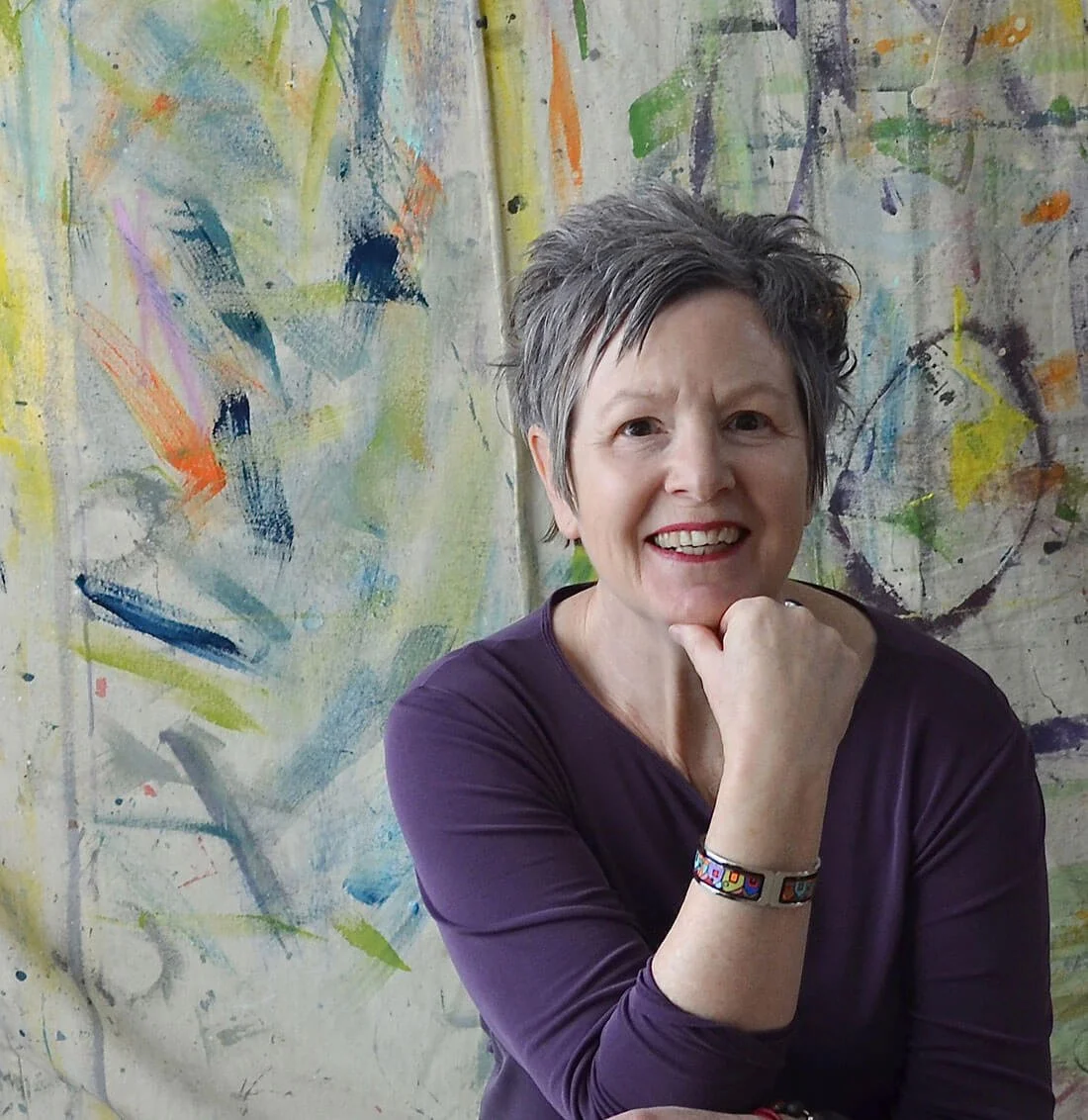 Woman in purple shoot with colourfully painted background