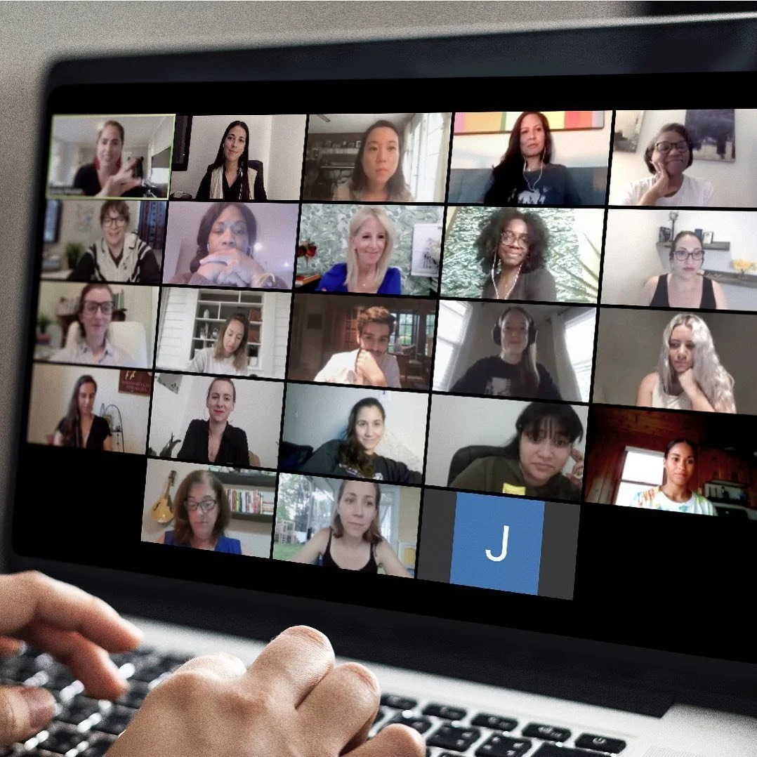 A person using a laptop to participate in a virtual video conference with 20 diverse women on the screen.