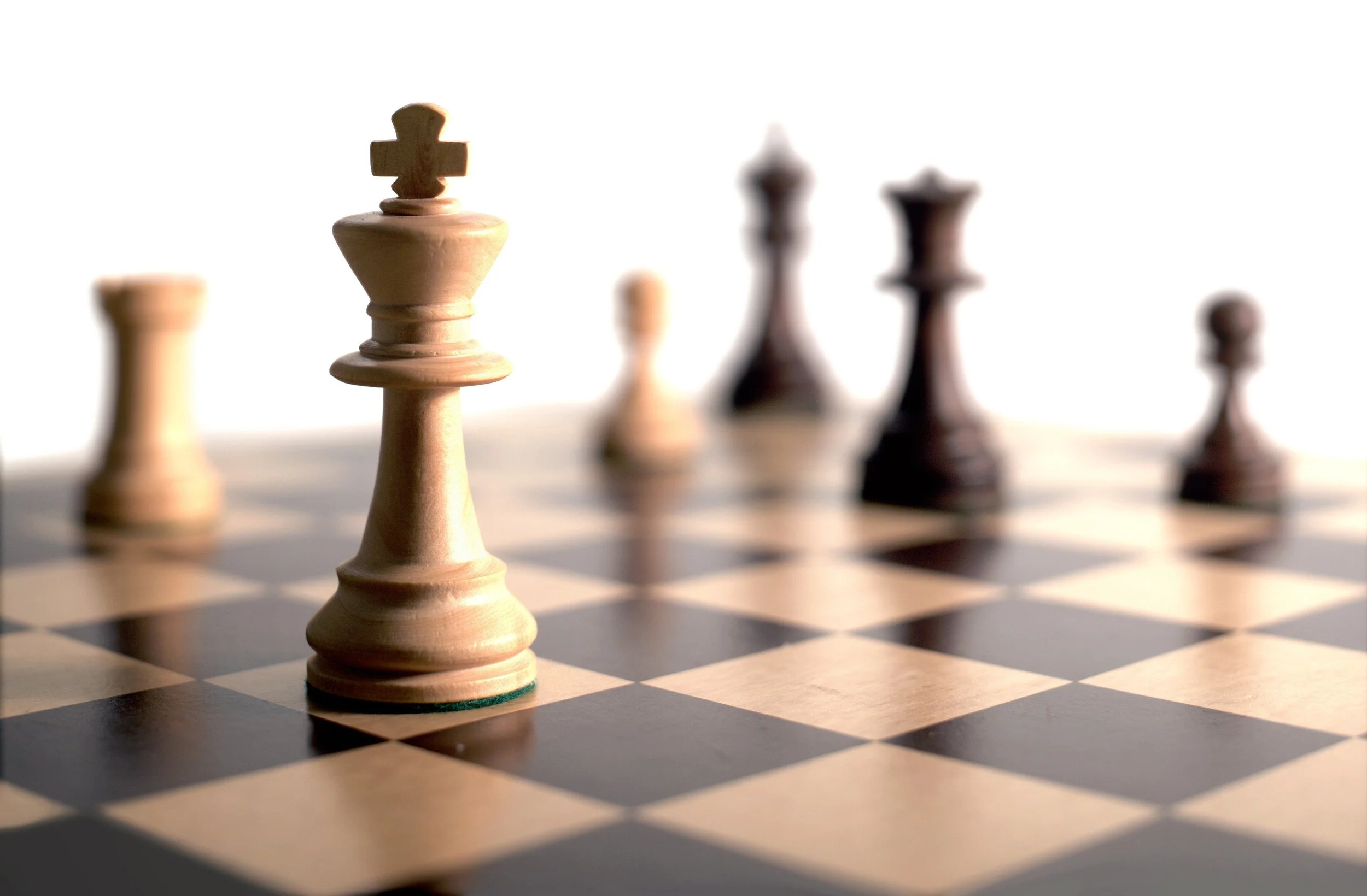 Close-up photo of black and white chess pieces on a chess board
