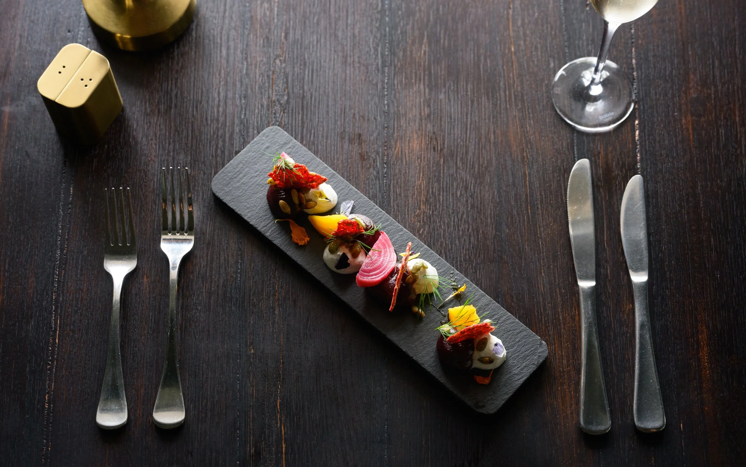 A three-tiered seafood platter with grilled octopus, oysters, and other assorted seafood.