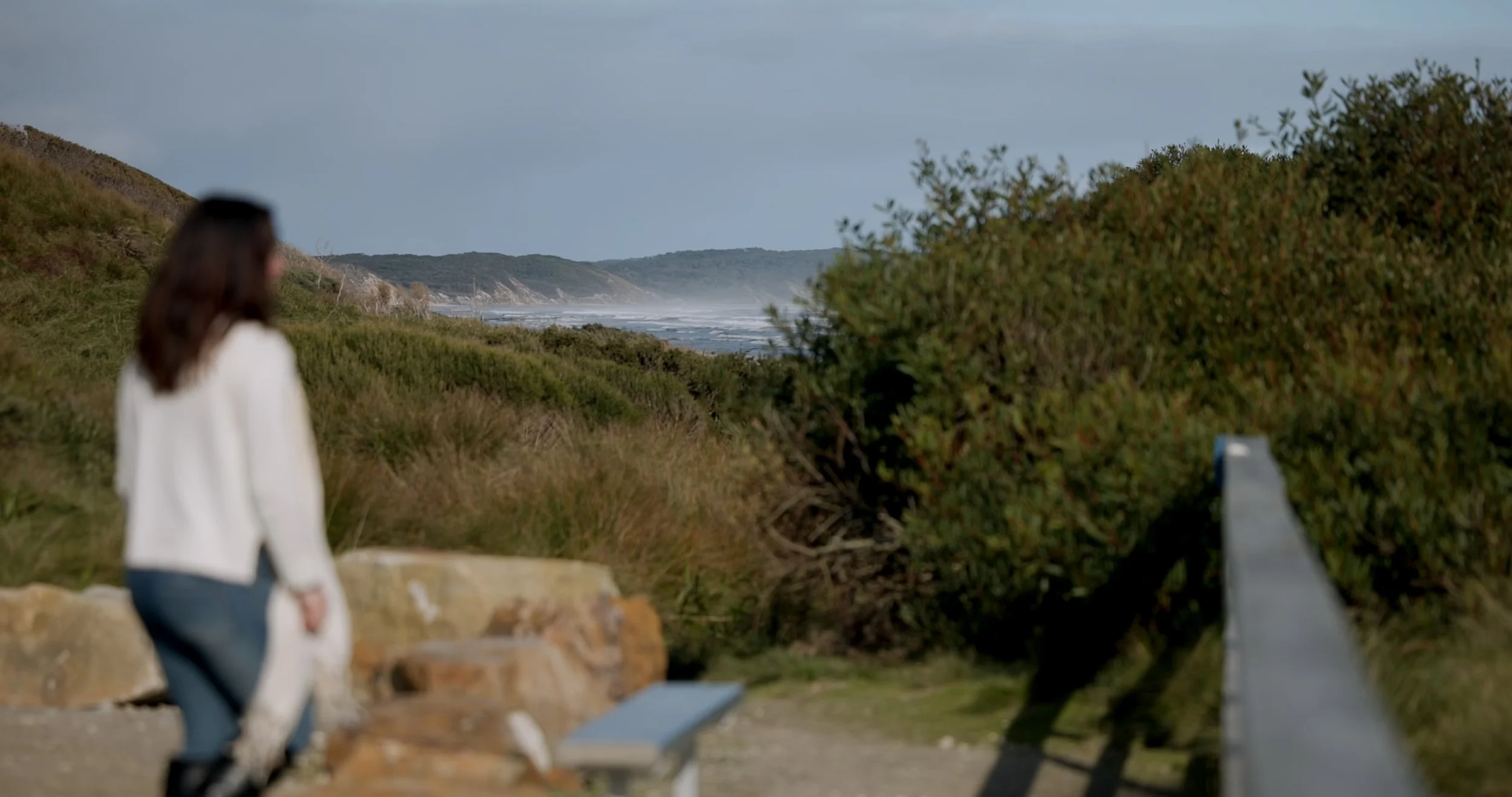 A lady walks down the path to the spectacular, windswept Ocean beach