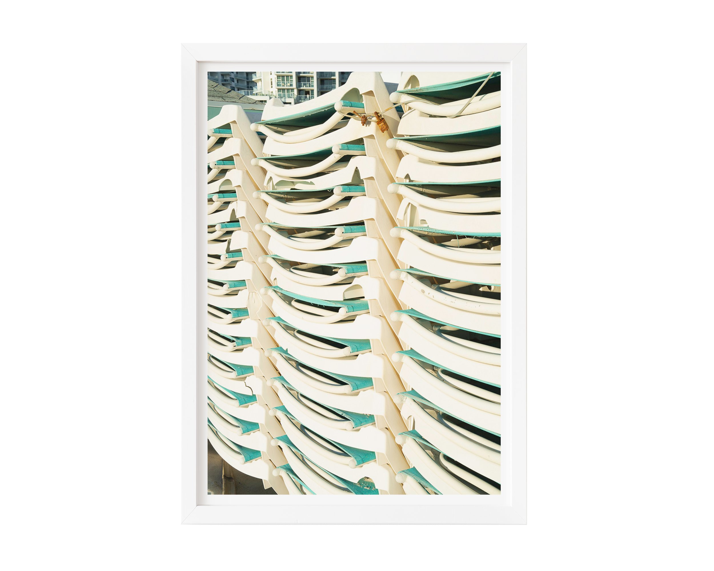 A modern fine art photograph featuring a tightly stacked row of sunlit white and teal lounge chairs, captured with crisp lines and rhythmic repetition.