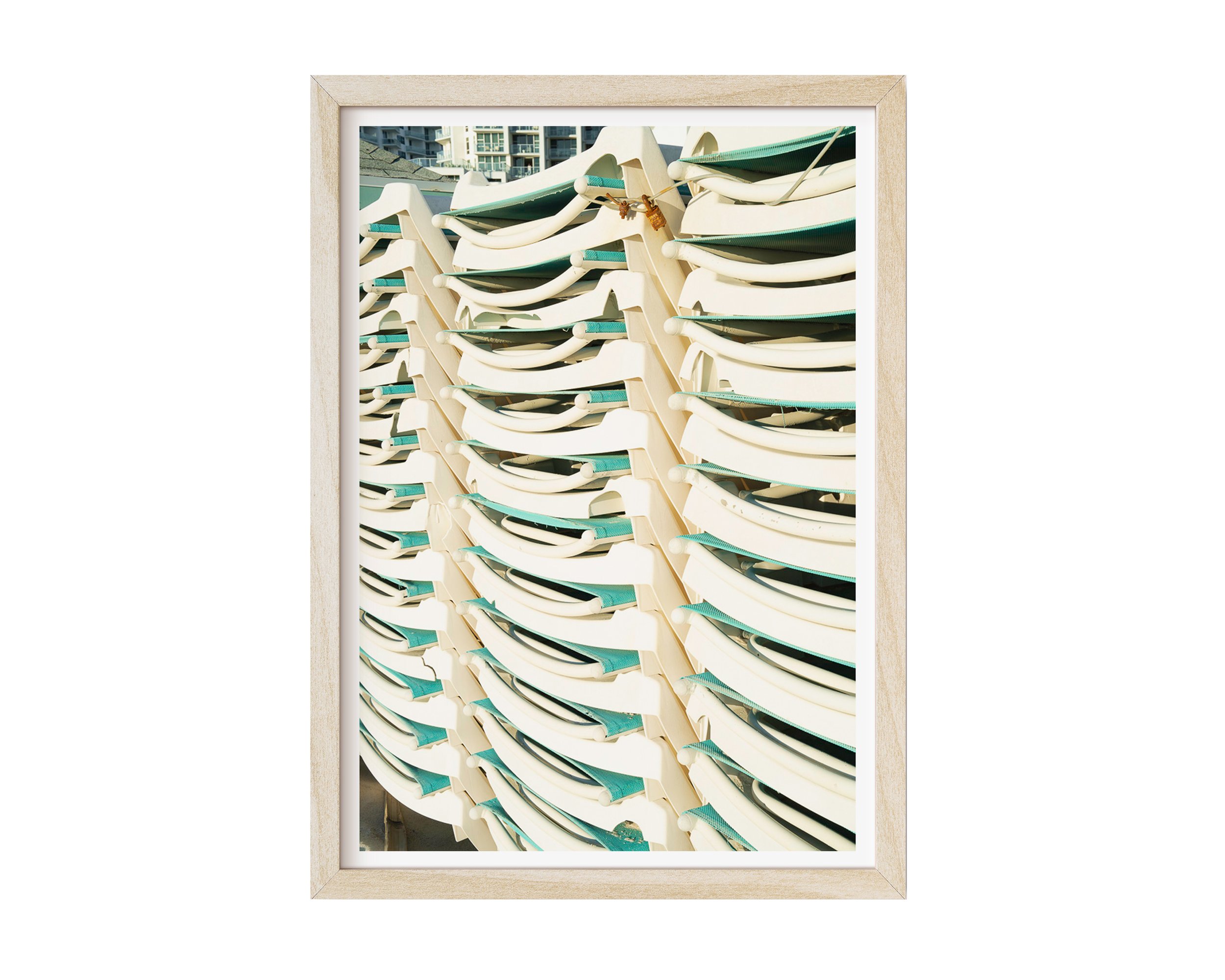 A modern fine art photograph featuring a tightly stacked row of sunlit white and teal lounge chairs, captured with crisp lines and rhythmic repetition.