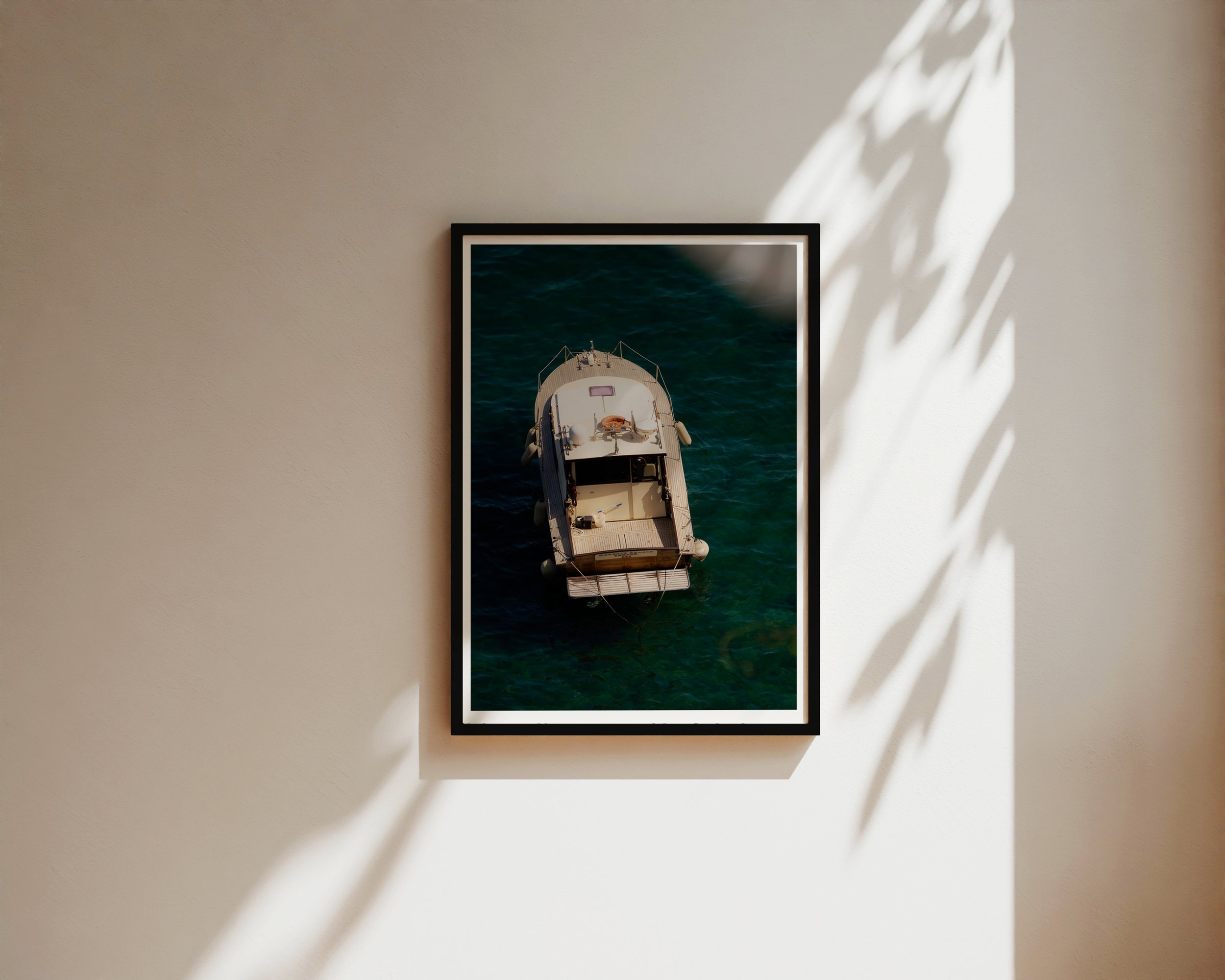 Overhead view of a vintage wooden boat floating in clear turquoise water along the Mediterranean coast, captured in golden sunlight – serene nautical fine art print by Nicole Toland Photography