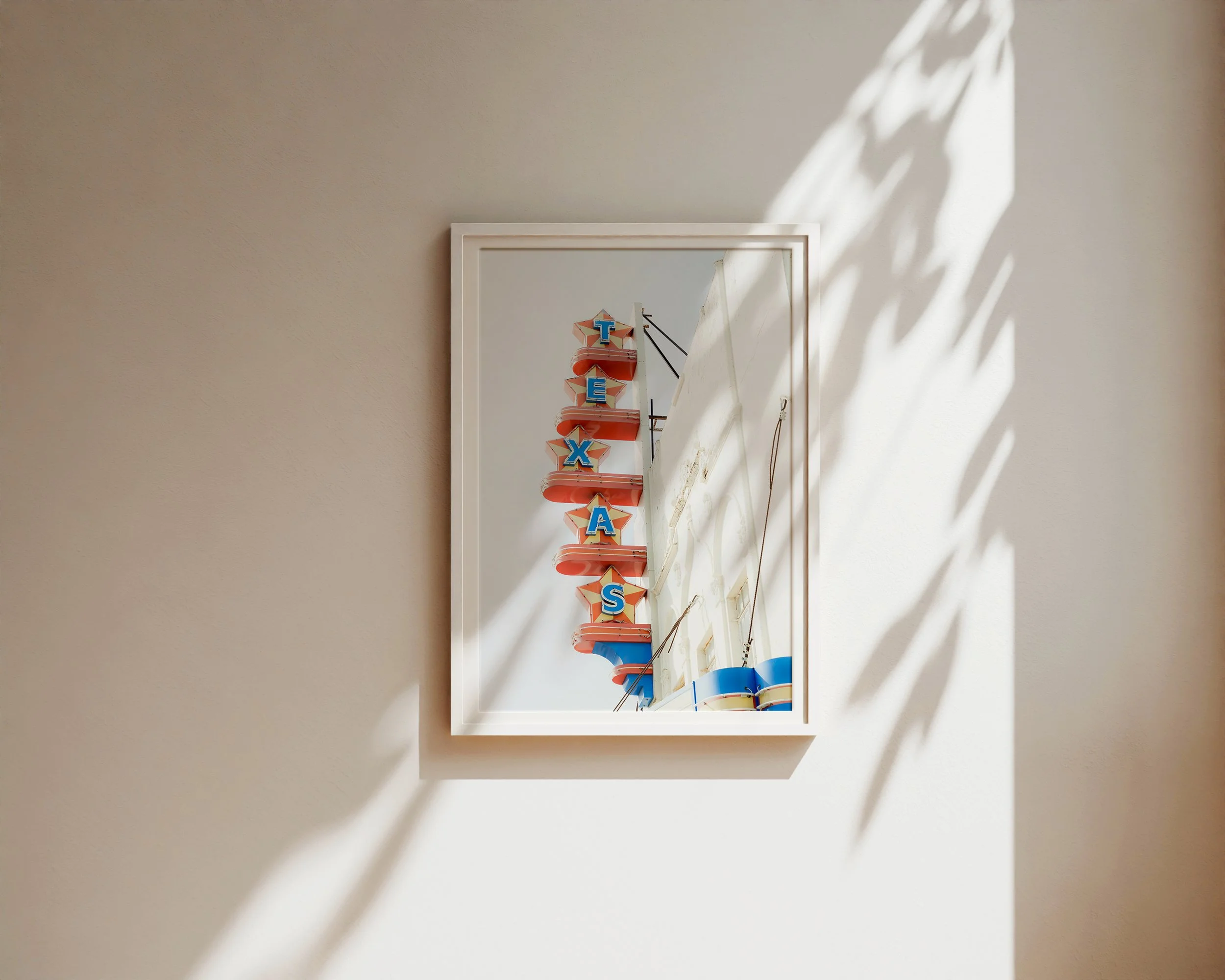 Vertical retro Texas sign with red and blue lettering on white building against soft sky