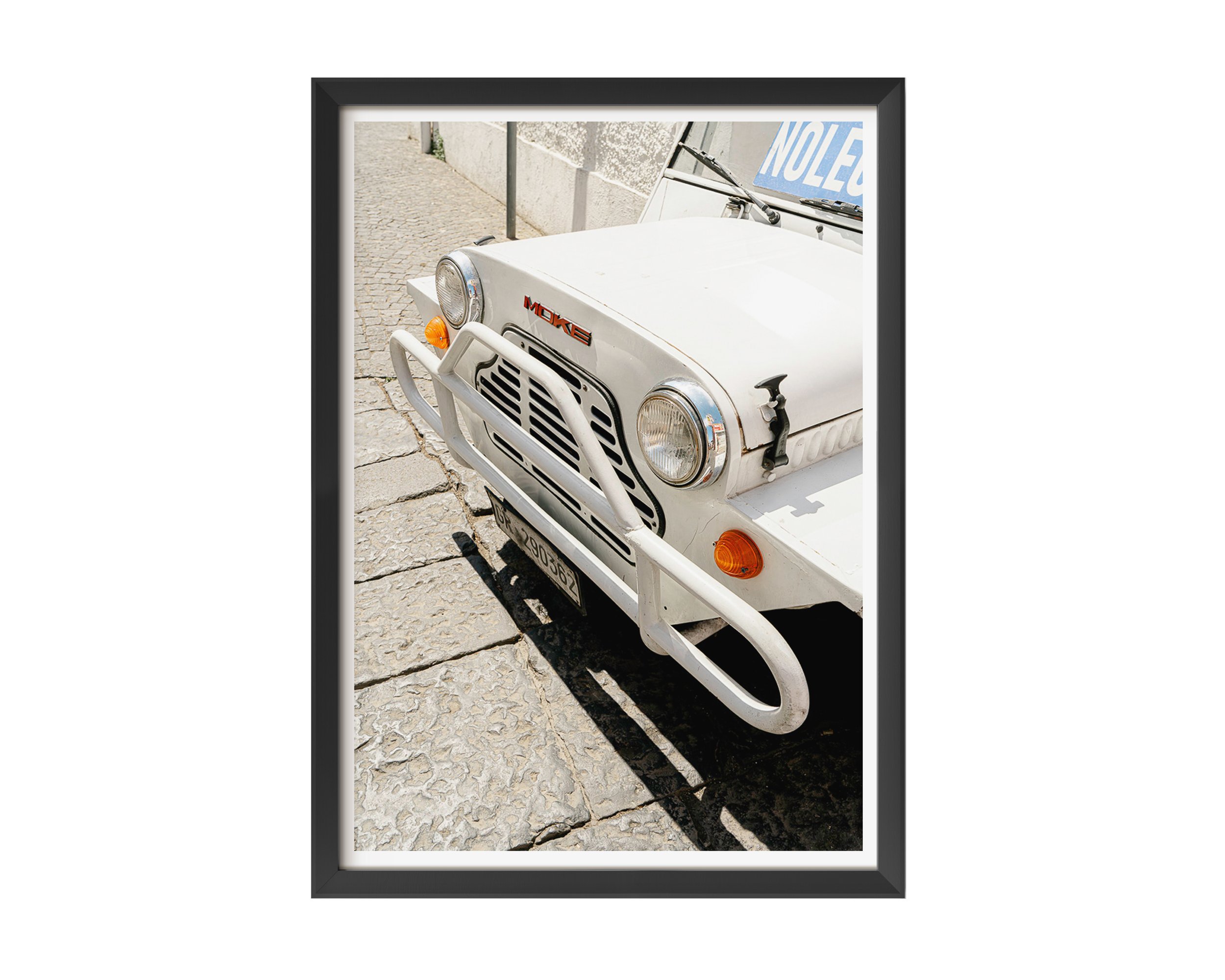 Close-up of vintage white Moke car parked on sunlit cobblestone street in Southern Europe, captured in golden daylight – retro travel photography print by Nicole Toland