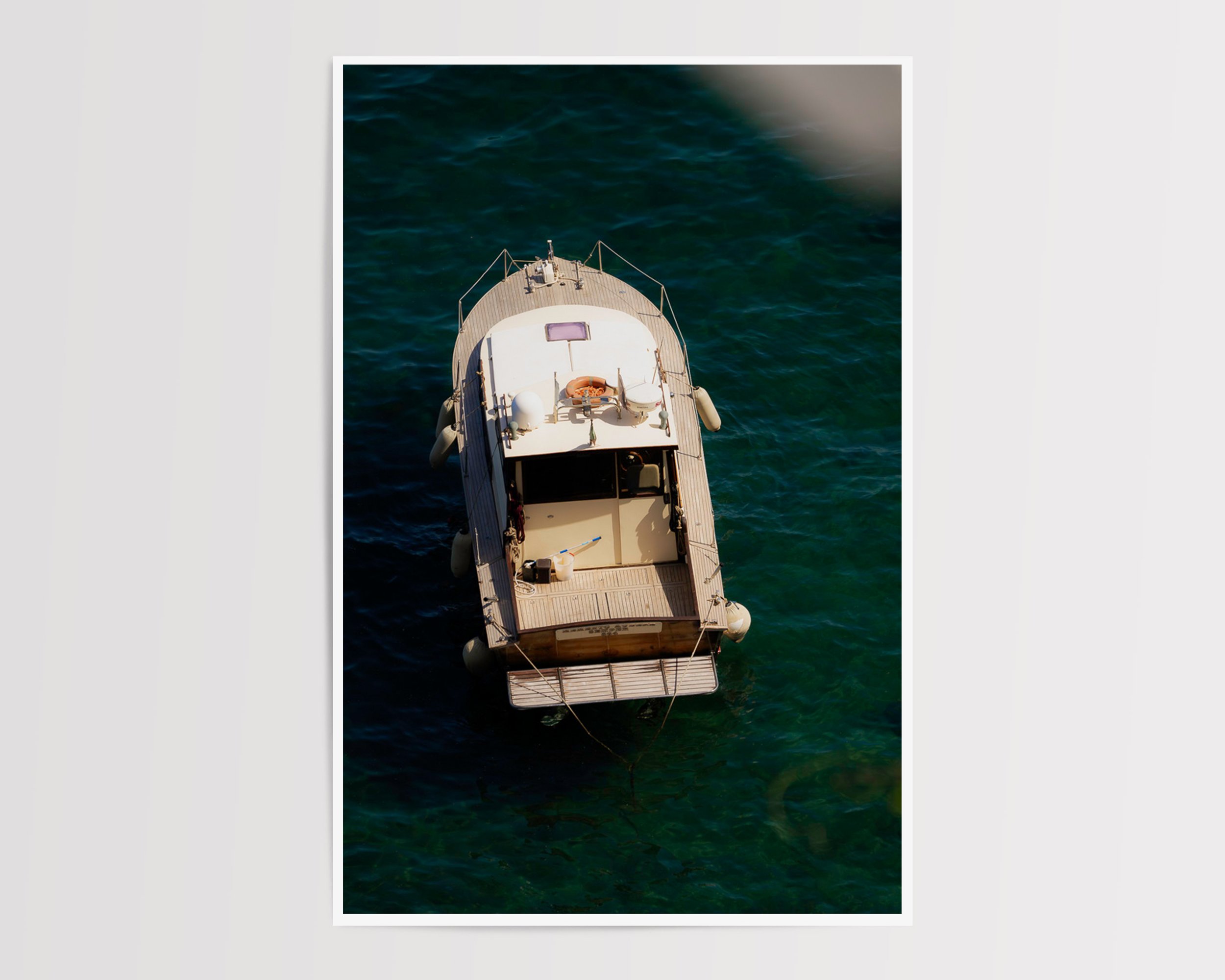 Overhead view of a vintage wooden boat floating in clear turquoise water along the Mediterranean coast, captured in golden sunlight – serene nautical fine art print by Nicole Toland Photography