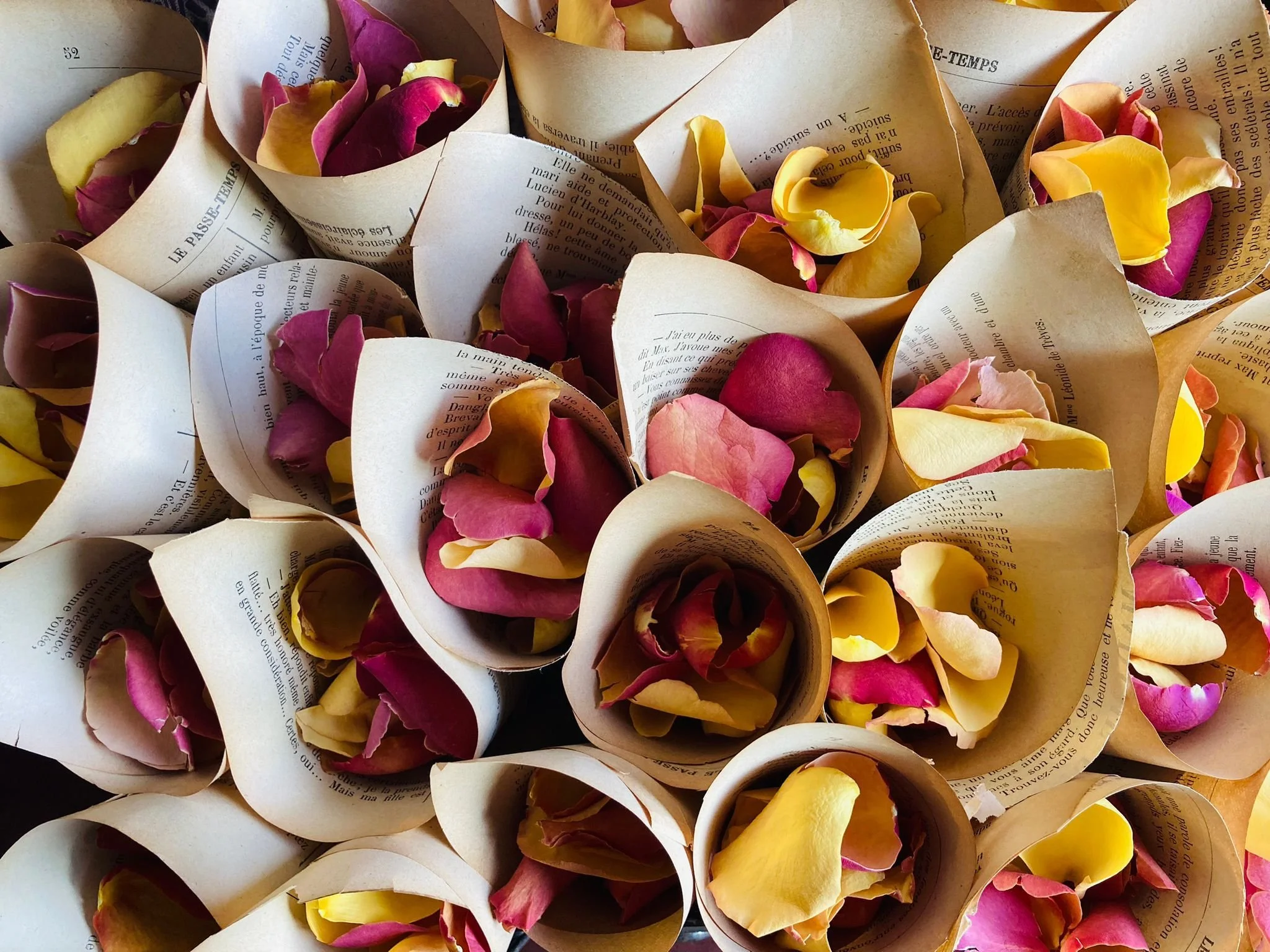Bouquet of paper cones filled with pink, red, yellow, and purple rose petals.