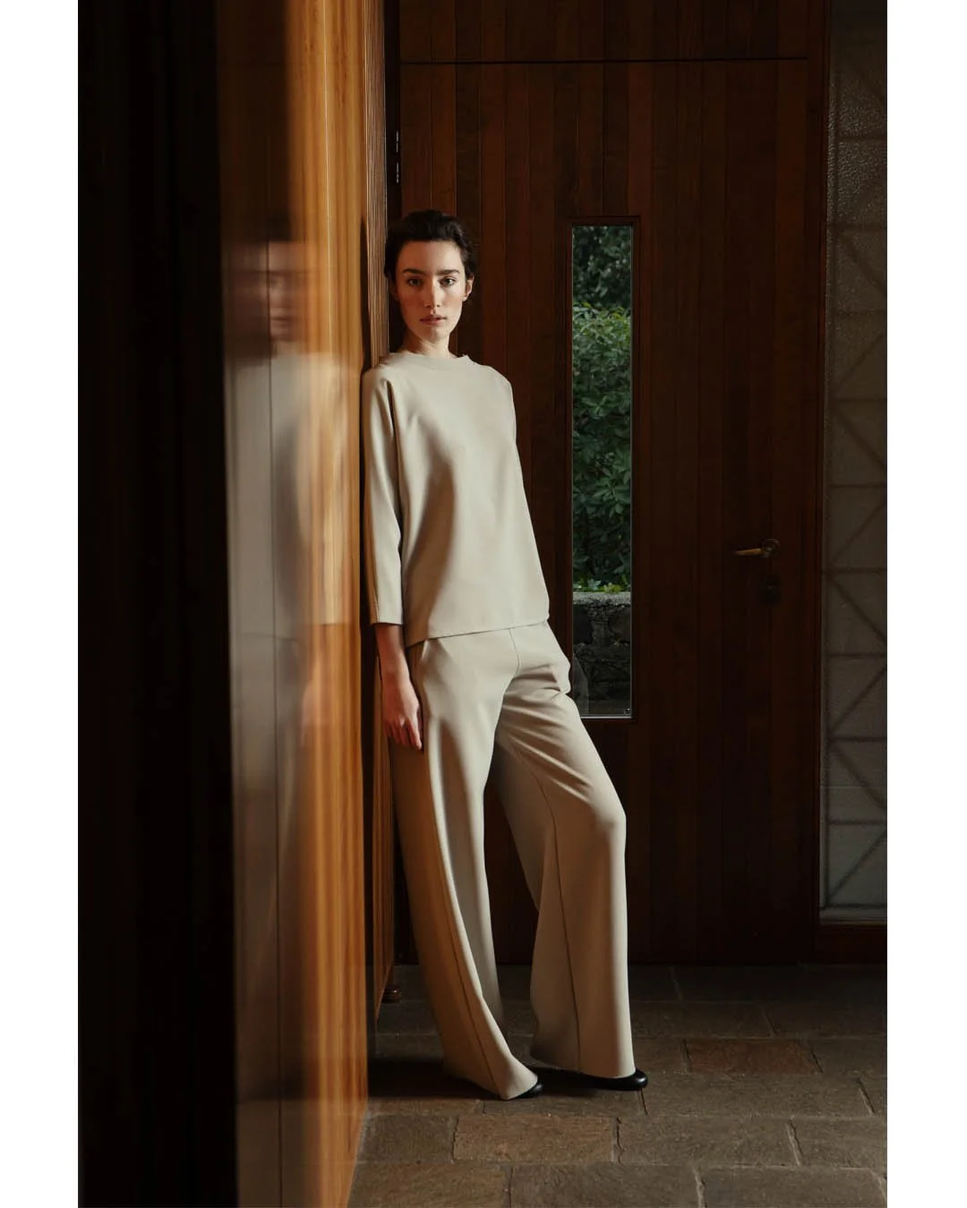 Today we present our fluid suit in a soft Almond Milk shade. Flared trousers paired with either a full-sleeve  top or a crater-neck tank. A minimal statement with maximum impact.