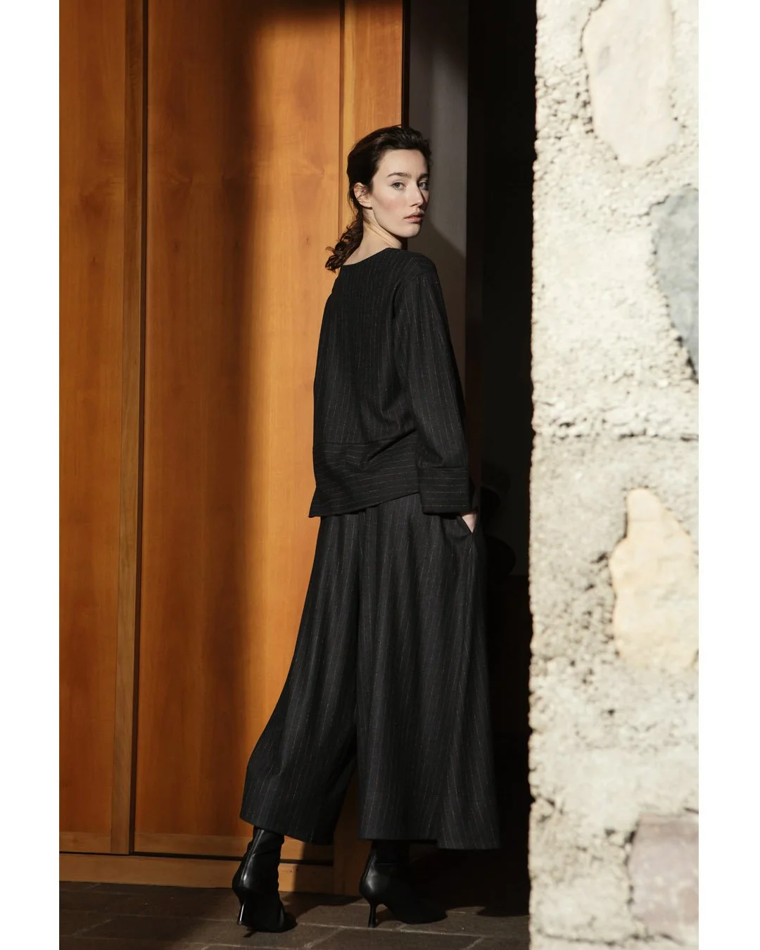 A total pinstriped look in a soft wool blend. Available in anthracite/tobacco and blue/grey. Designed with generous, fluid volumes for effortless elegance.