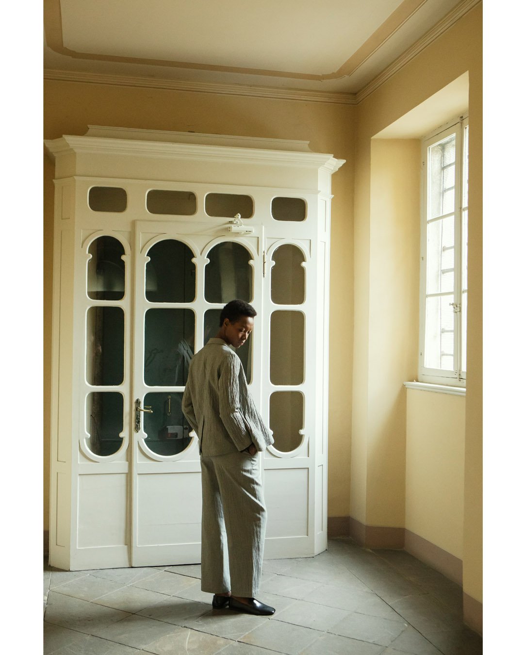 SOFT LIGHT. A quiet interplay of light and texture. Our jacket-and-trouser suit in a crinkled salt-and-pepper cotton blend brings a relaxed sensibility to classic tailoring.