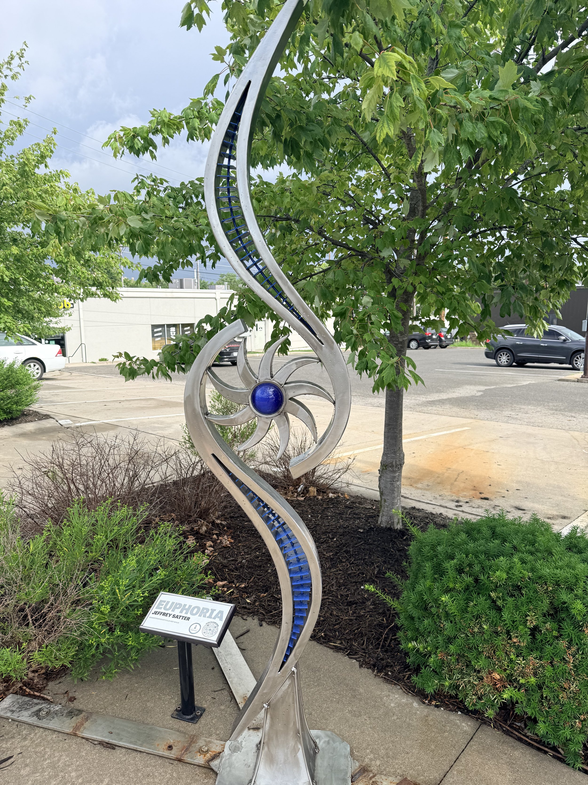 A curved sculpture with a blue gem in the middle.