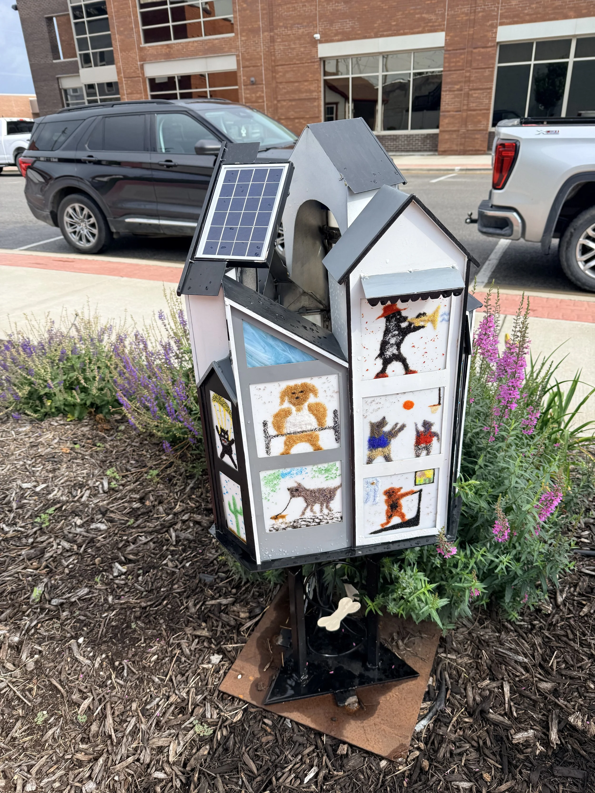 A small house structure with dog illustrations in the windows.