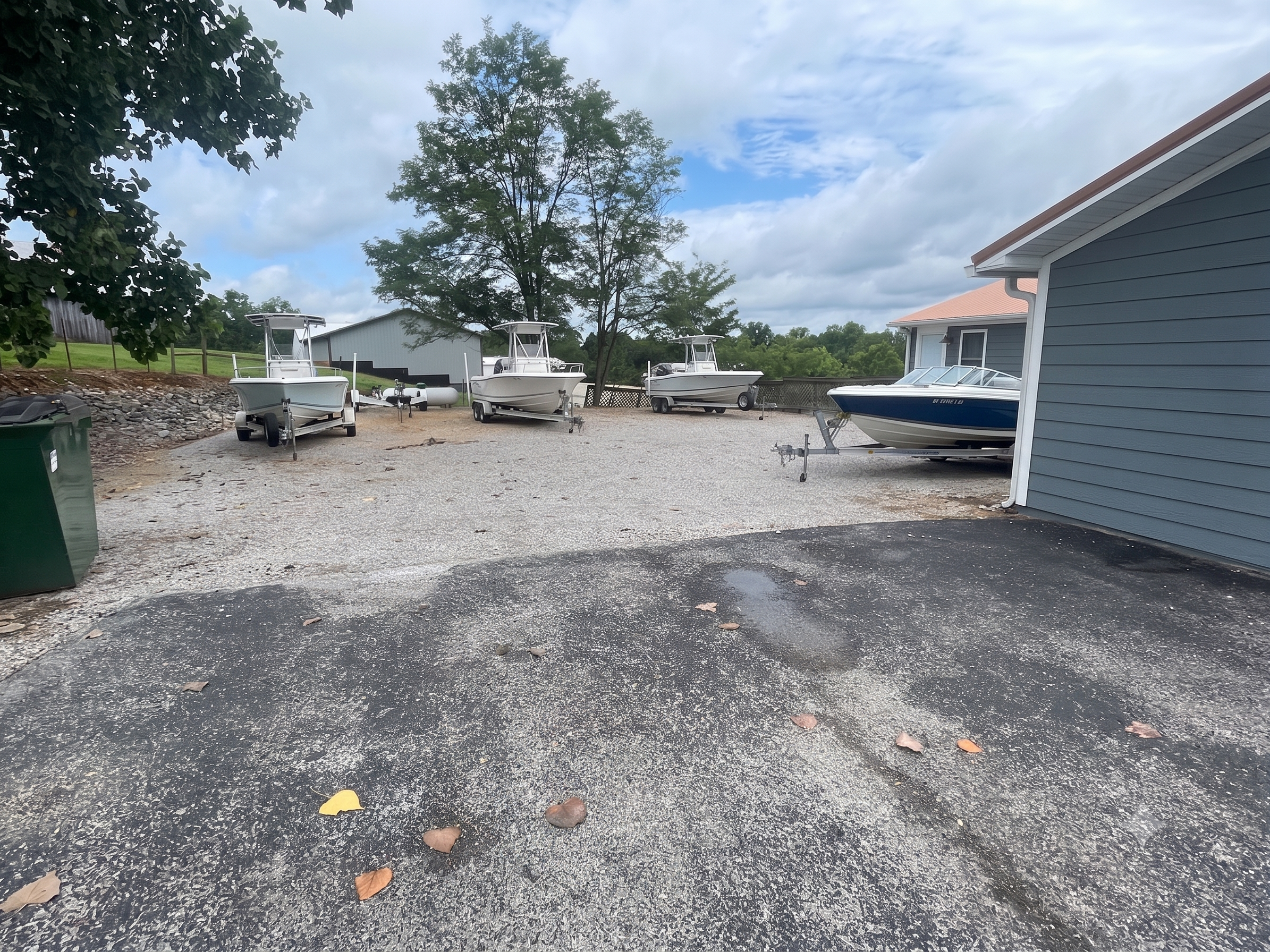 Wide, accessible gravel parking area at Lakeside Inn with multiple 20-foot boats on trailers parked securely overnight.