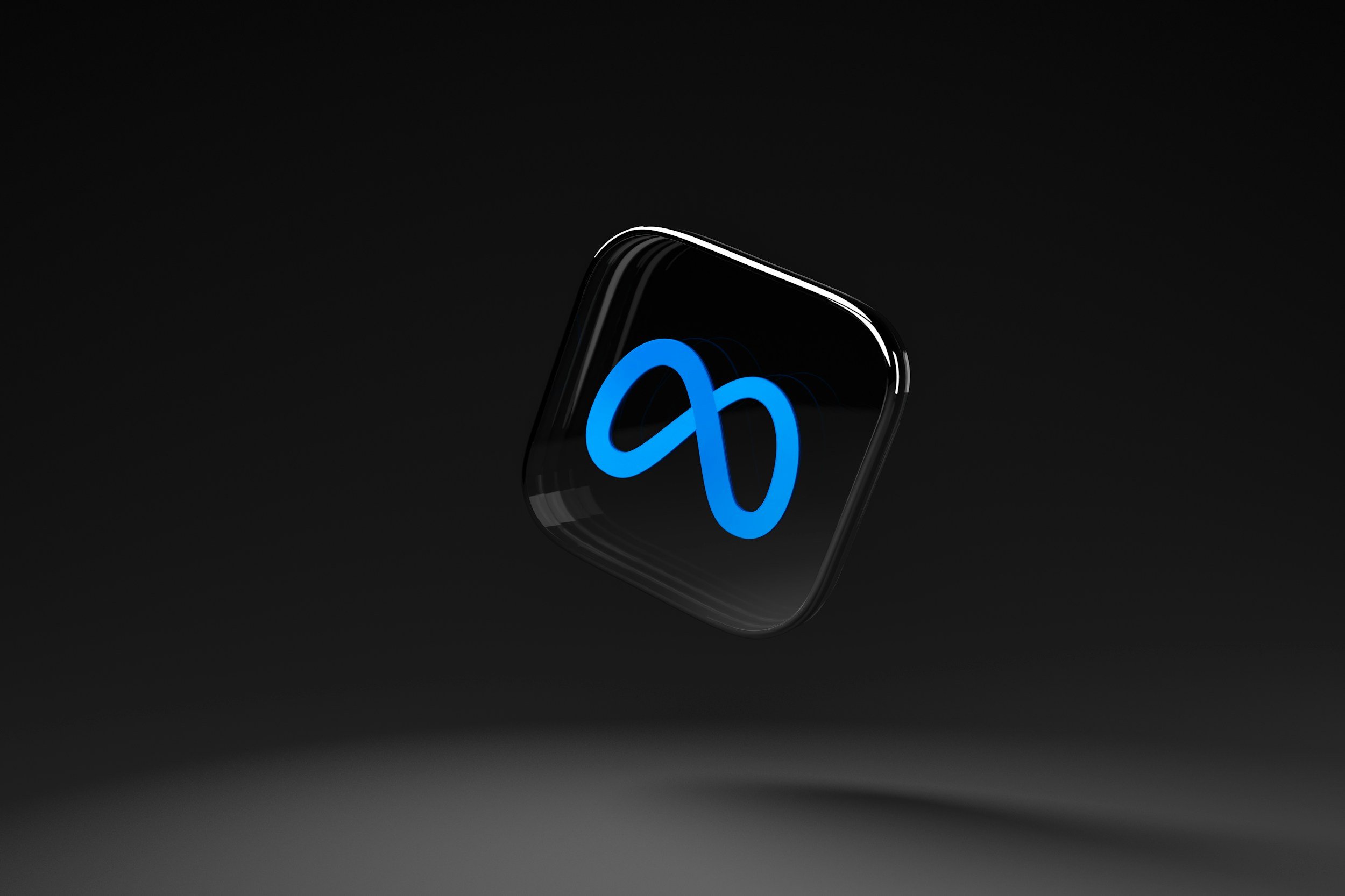 Close-up of a smartphone with a blue infinity symbol on the screen, set against a dark background.