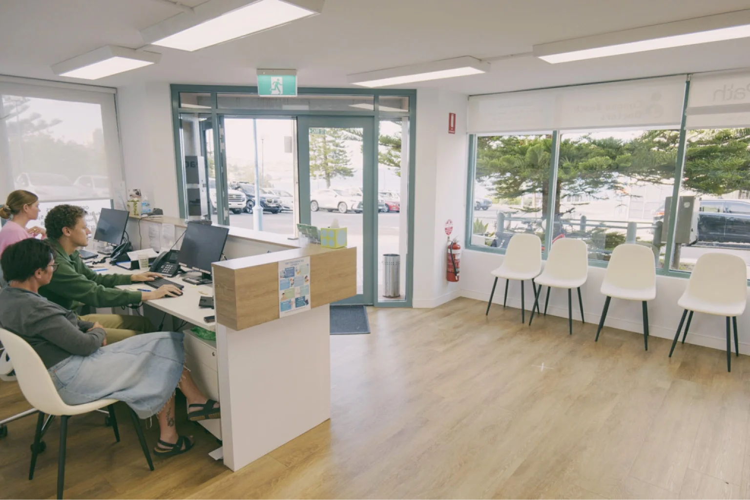 Reception and waiting area at Coogee Beach Doctors, with light-filled windows opening onto Carr Street.
